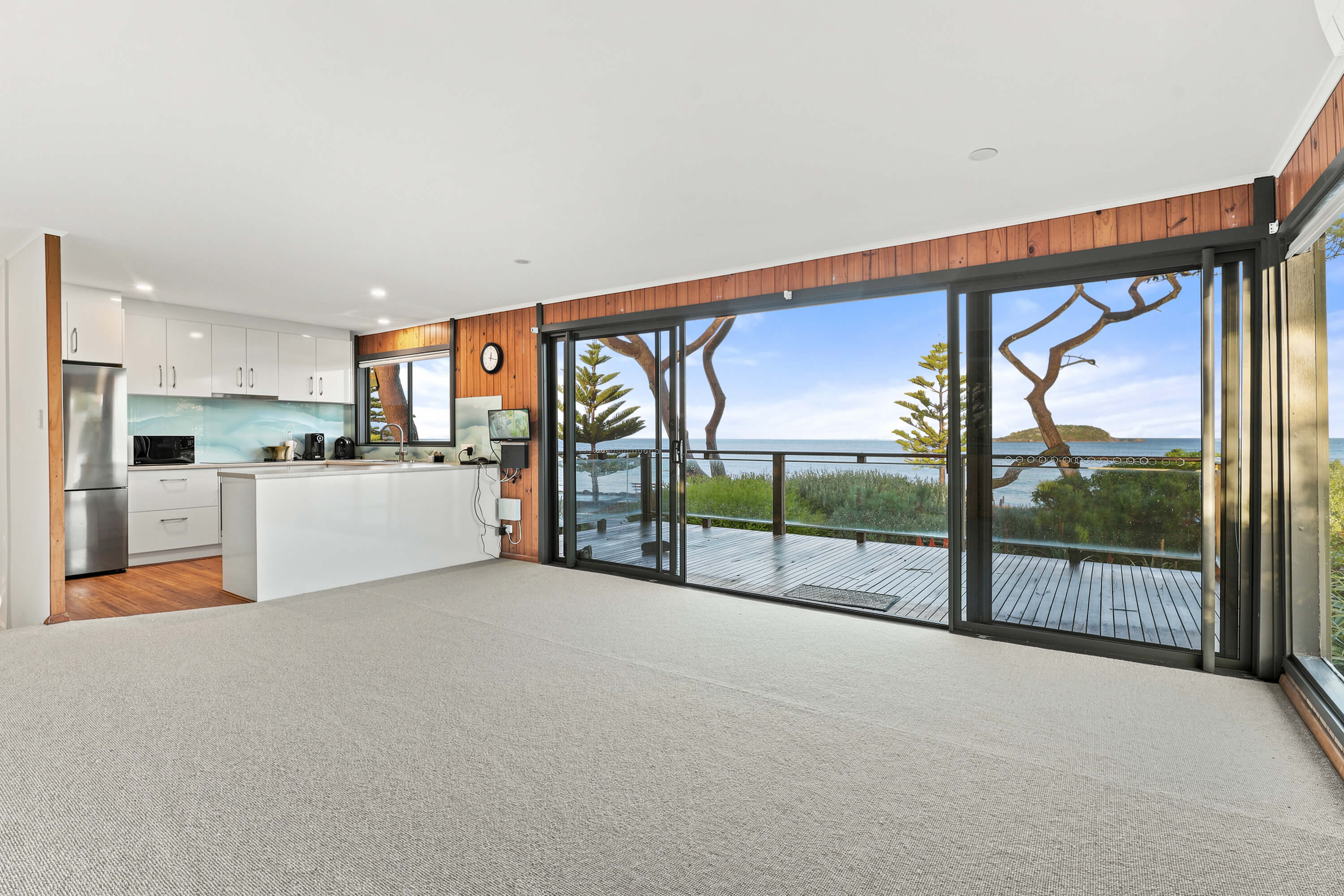 Open plan living with white kitchen and full-width sliding doors to the sea-view deck at Franklin Ave, Encounter Bay