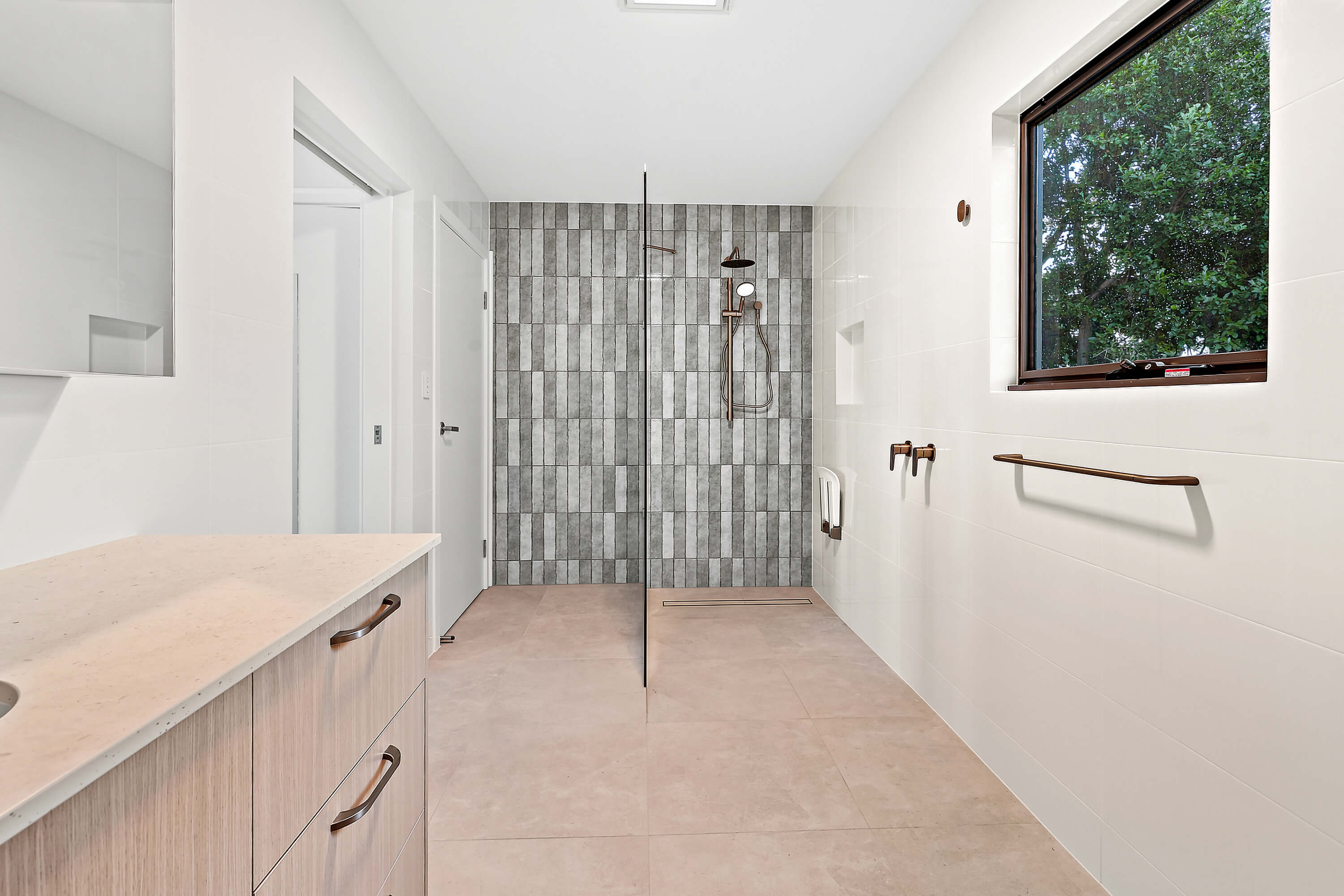 Walk-in shower with grey feature tiles and black-framed screen at Franklin Ave, Encounter Bay