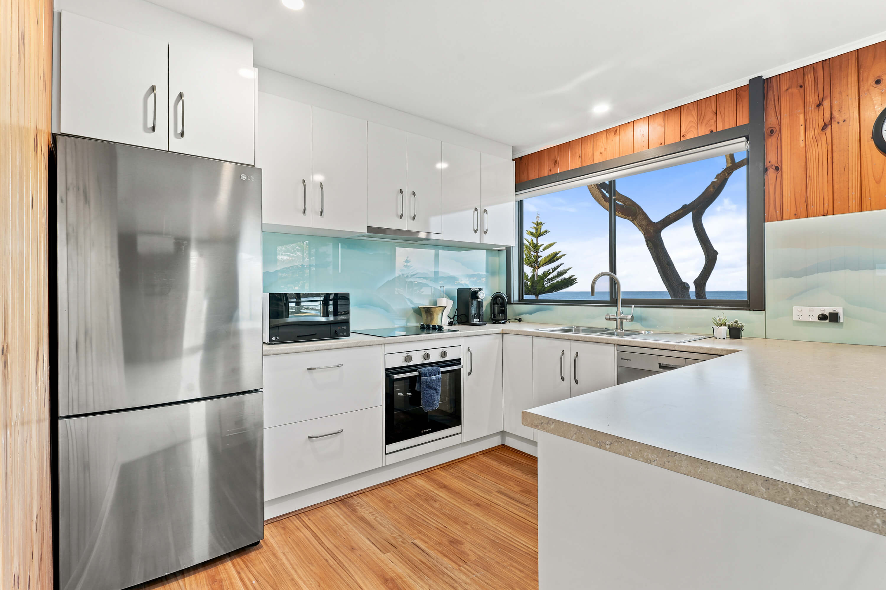 White kitchen with sea view window and original timber lining at Franklin Ave, Encounter Bay