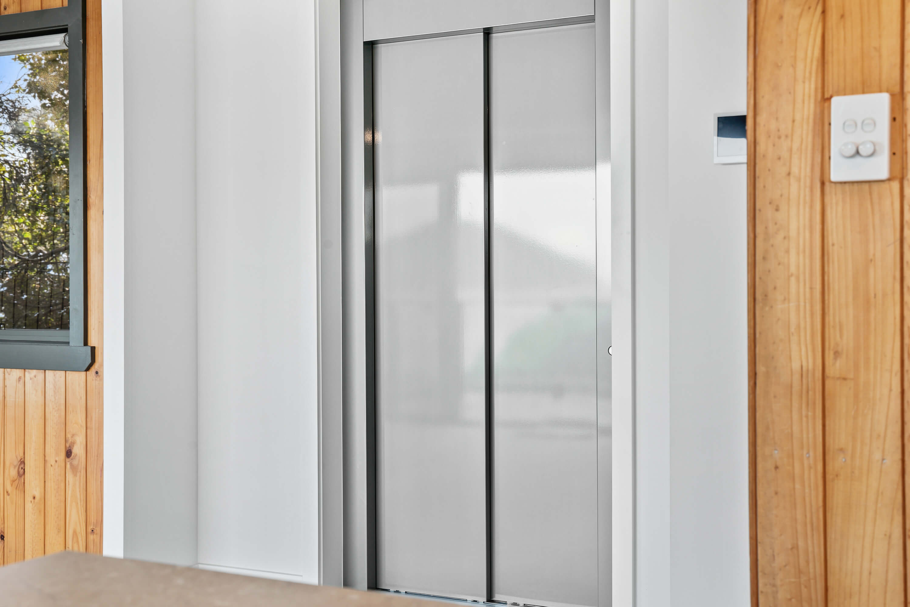 Residential lift doors set into timber-lined walls at Franklin Ave, Encounter Bay
