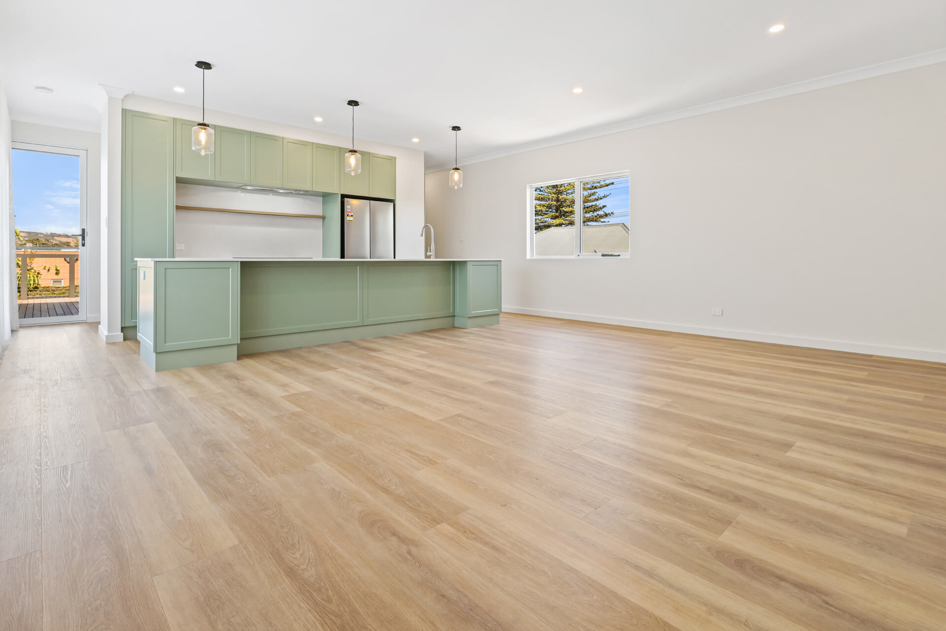 Open plan living and sage green kitchen with new timber-look floors at Victoria St, Victor Harbor