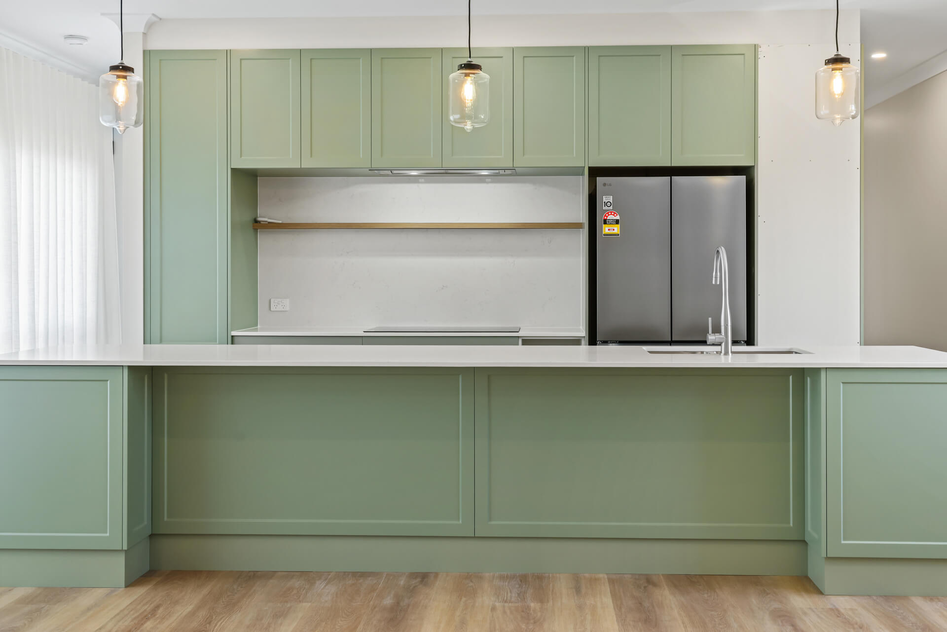 Sage green kitchen wall with integrated fridge cavity and stone benchtops at Victoria St, Victor Harbor