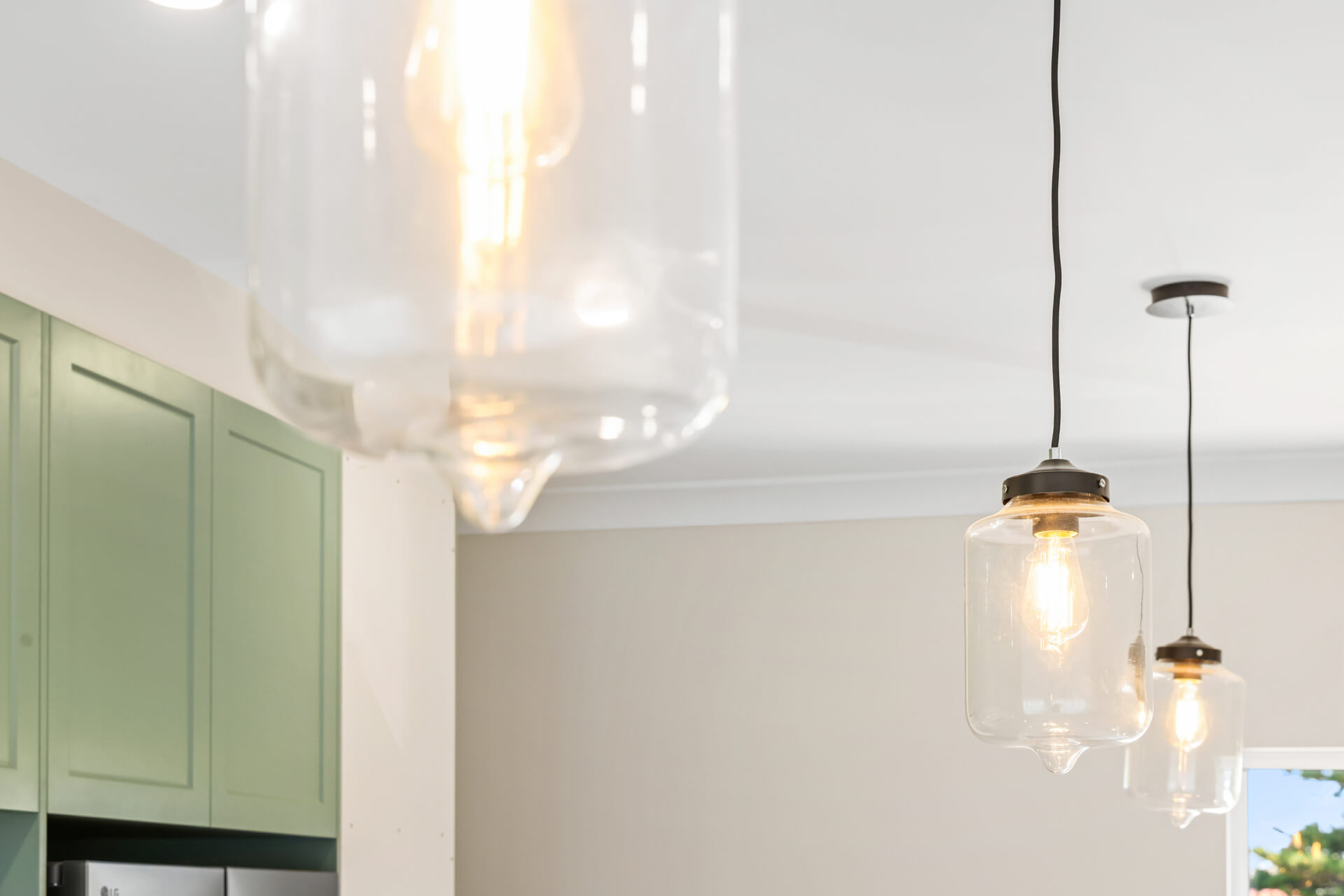 Glass pendant lights over the sage green kitchen at Victoria St, Victor Harbor
