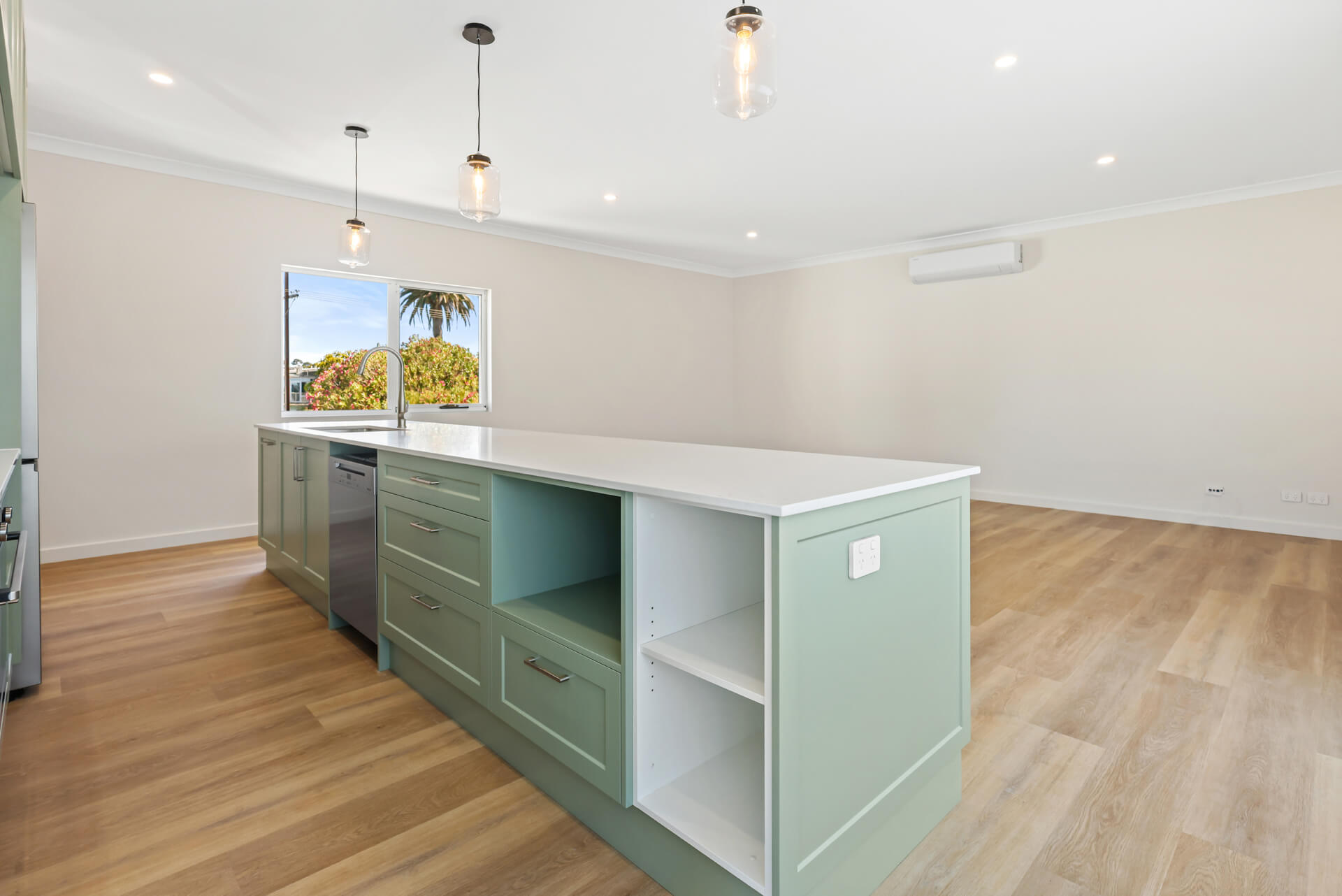 Sage green island bench with timber-look flooring in the open plan living area at Victoria St, Victor Harbor