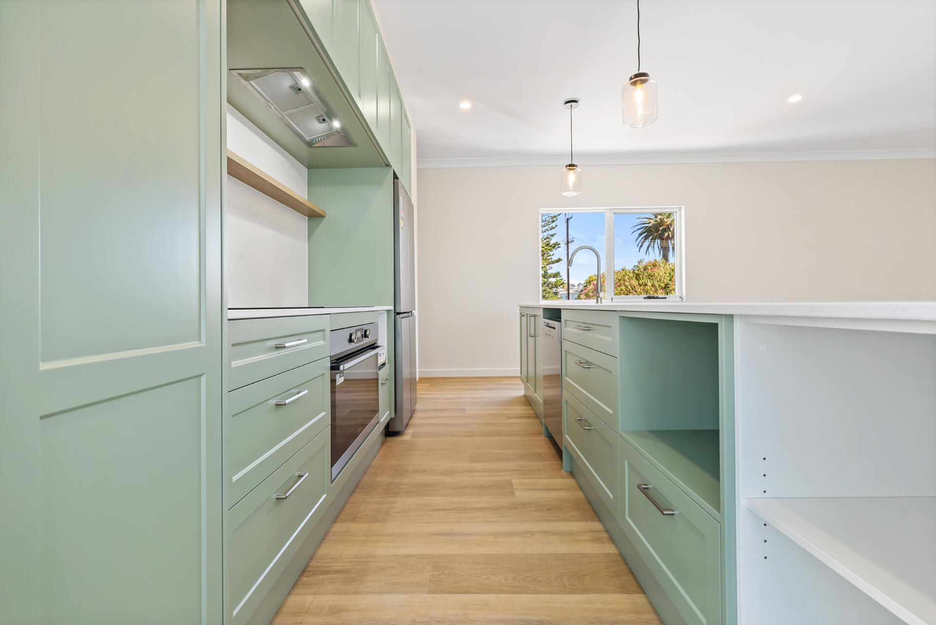 Sage green galley kitchen with island storage and pendant lighting at Victoria St, Victor Harbor