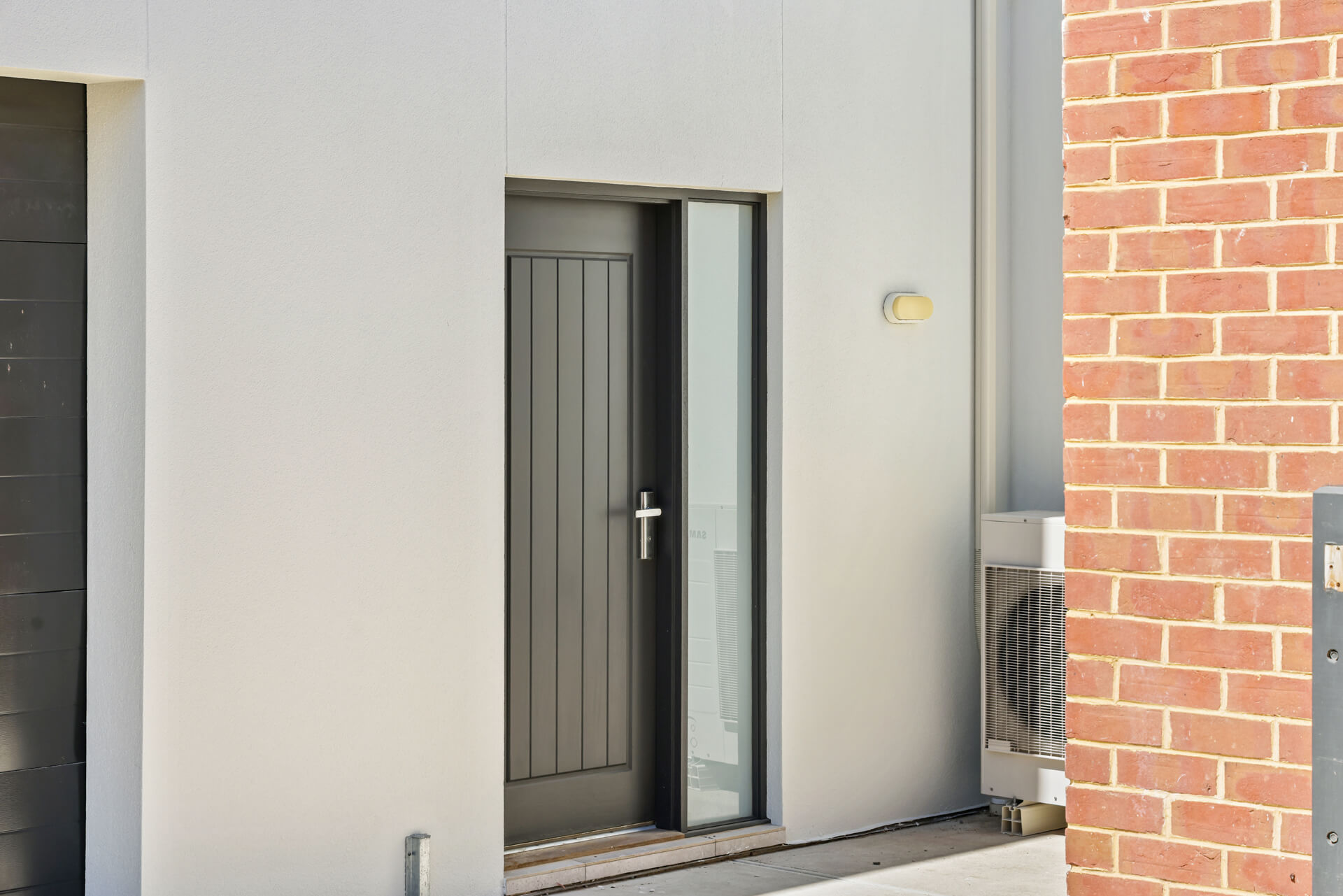New rendered entry with grey panel door beside original red brick at Victoria St, Victor Harbor