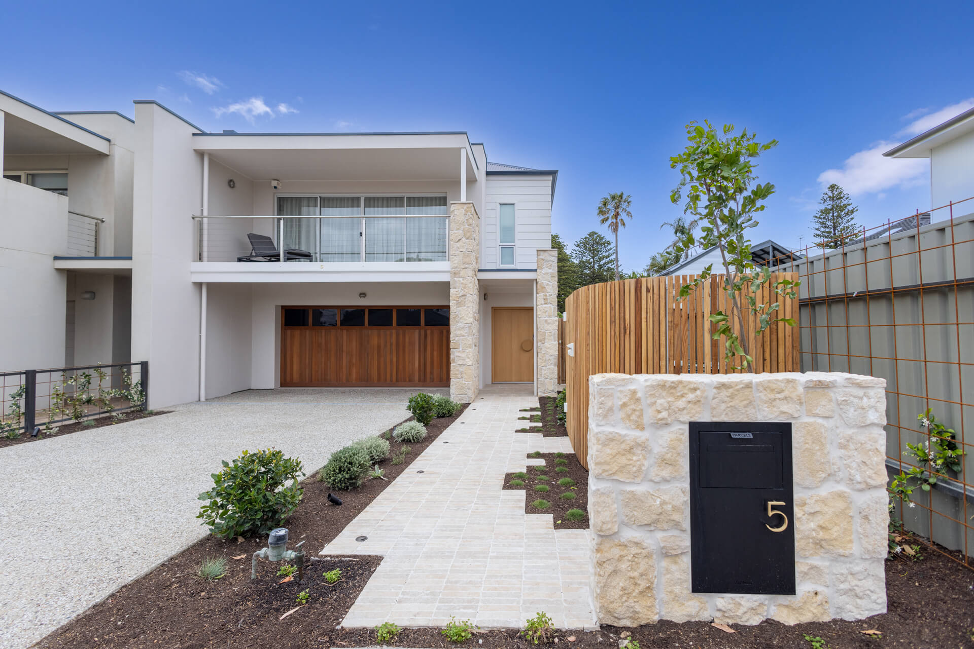 Street frontage of Henry St, Port Elliot, with limestone letterbox pier, timber battens and two storey rendered facade