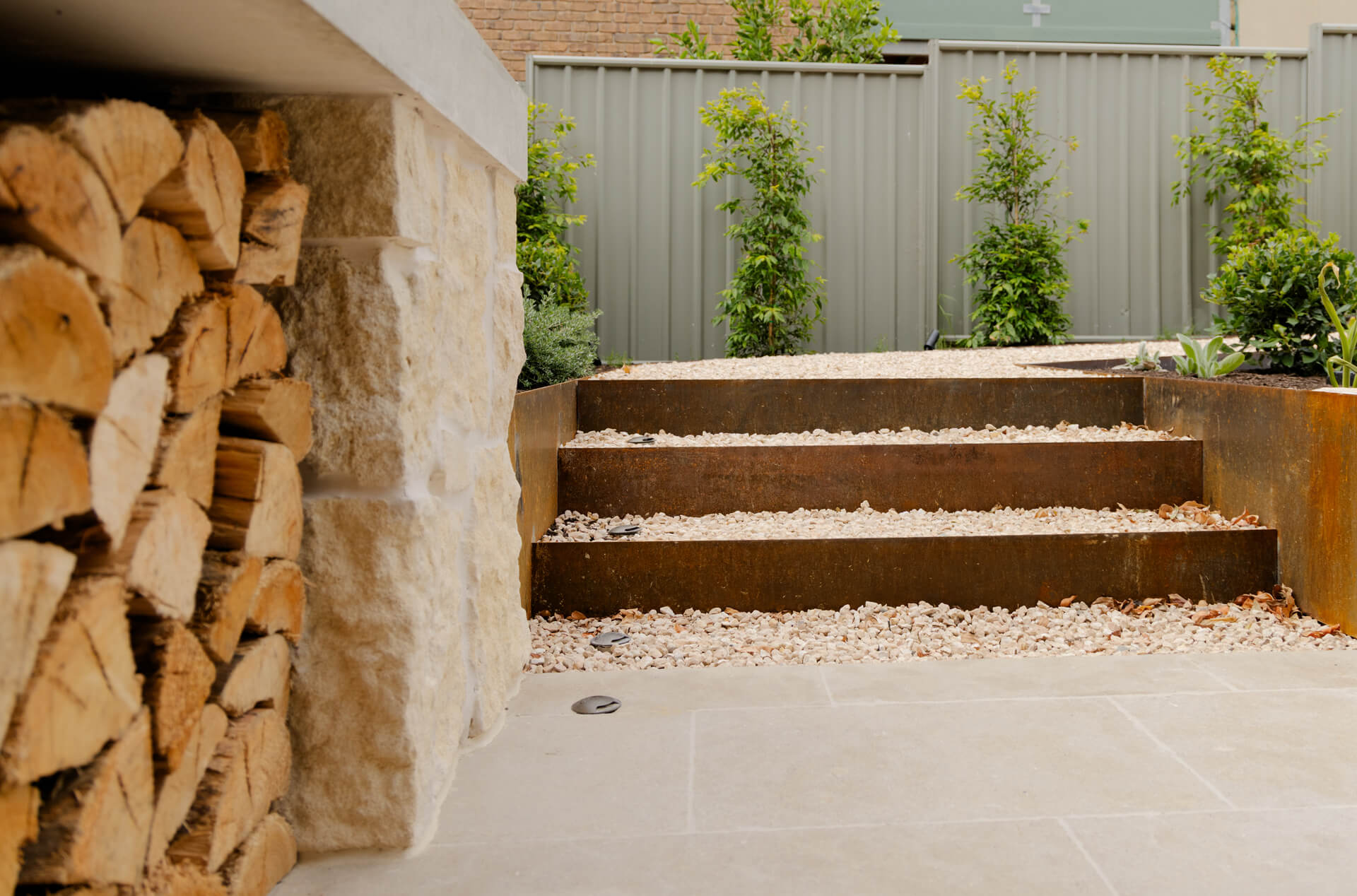 Corten steel garden steps beside a stacked firewood store and limestone pier at Henry St, Port Elliot