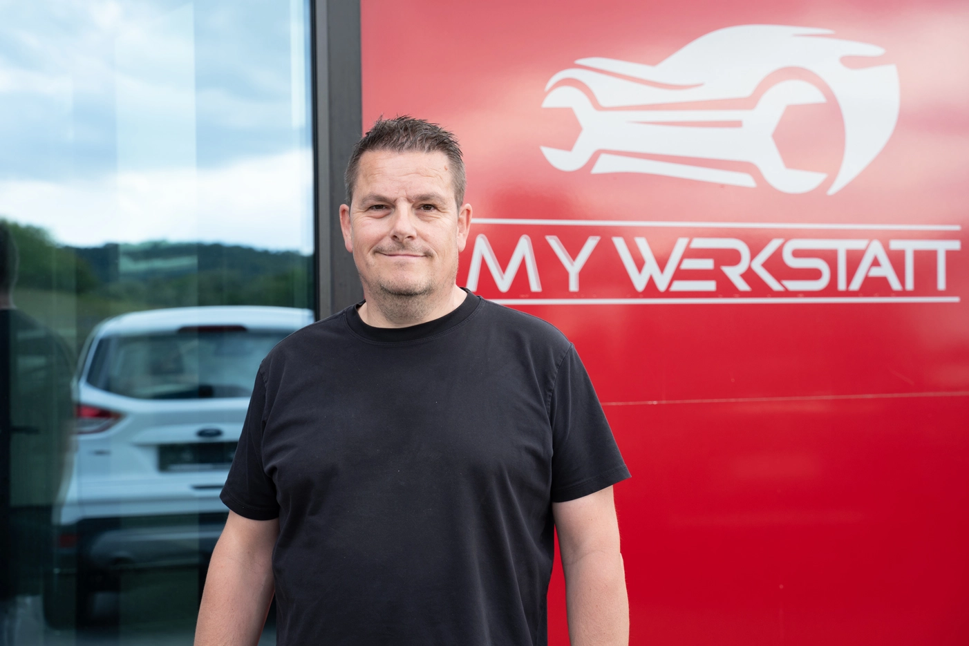 Mechaniker arbeitet mit Werkzeug an einem Fahrzeug in der Werkstatt