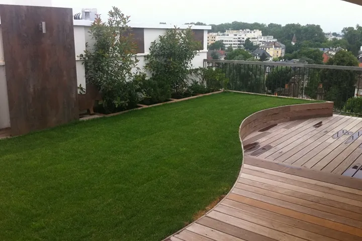 Terrasse en bois longeant une pelouse
