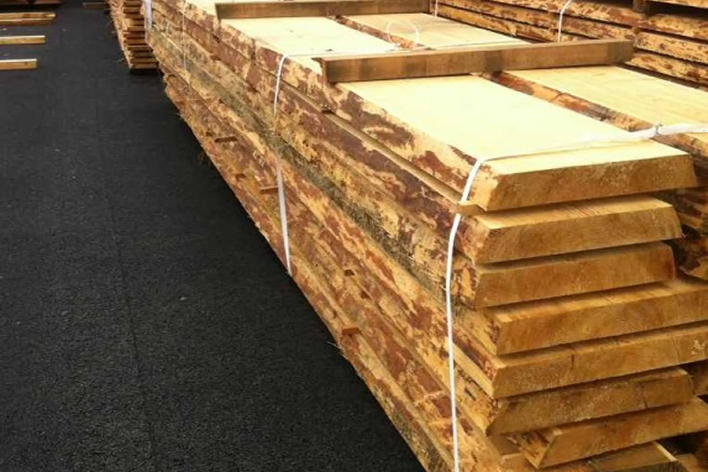 Piles de bois scié stockées sur le parc de Strub Bois