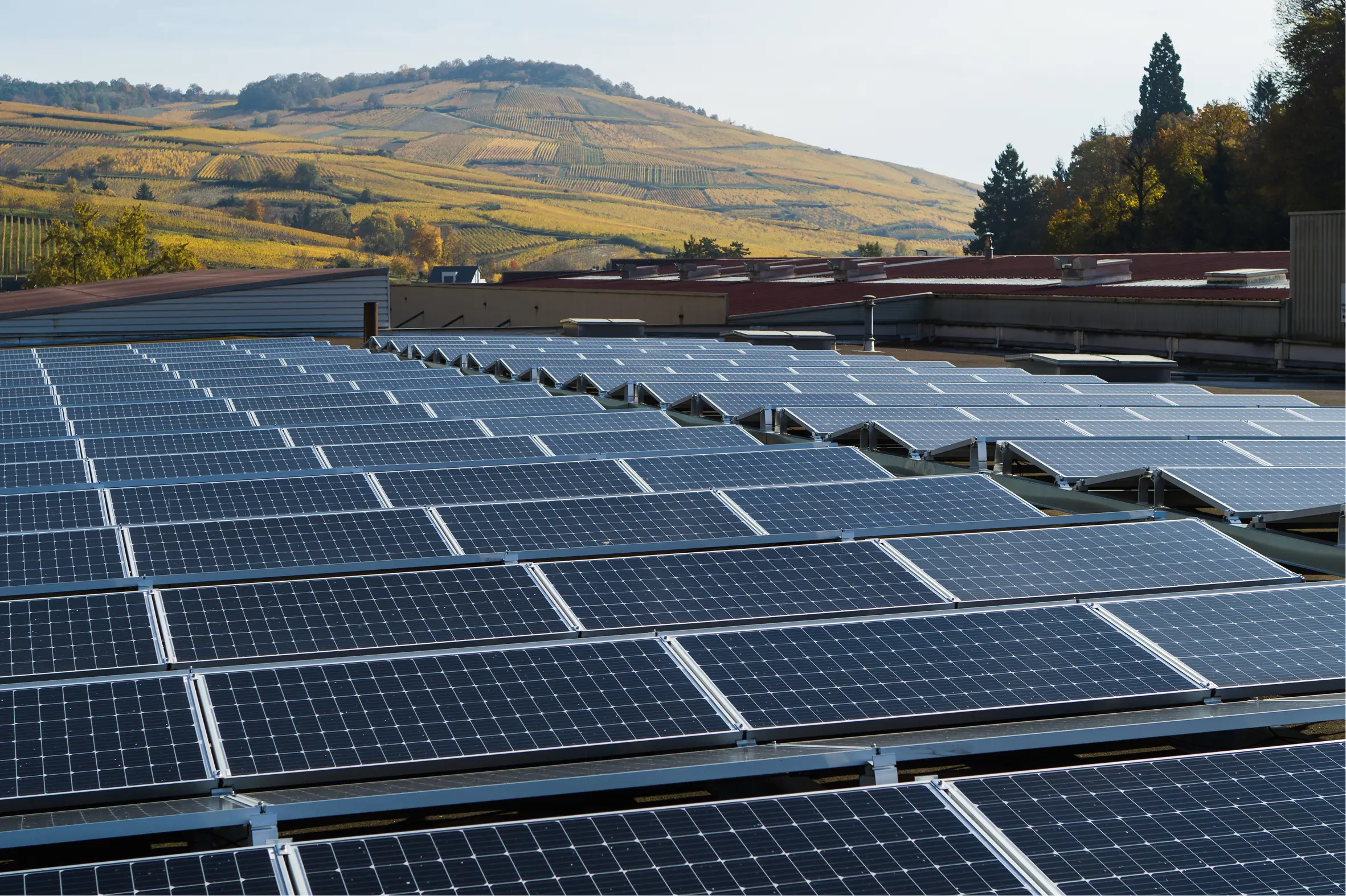 Panneaux photovoltaïques installés en toiture, collines en arrière-plan