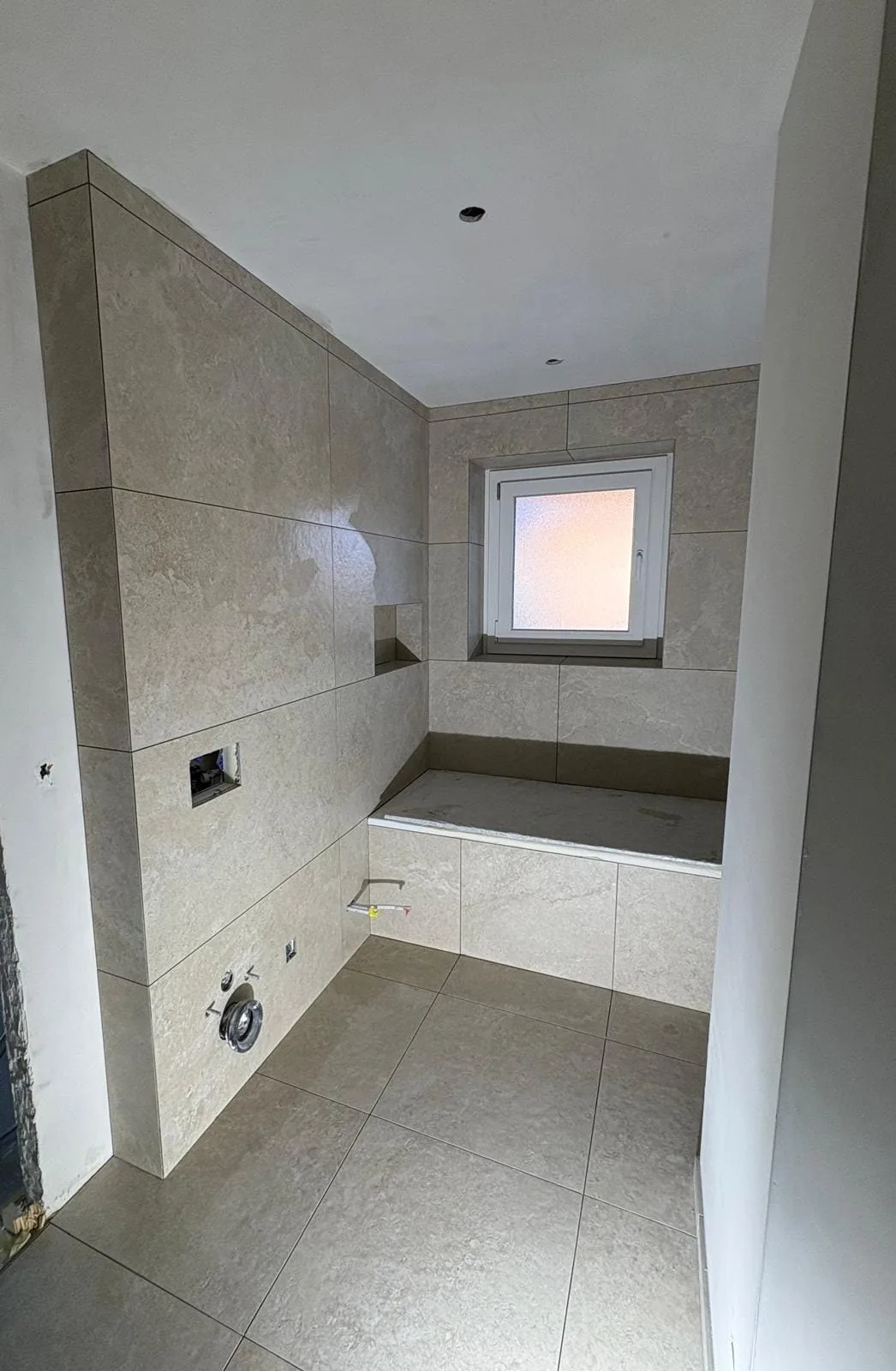 Habillage carrelé de la baignoire et niche sous la fenêtre à Bogis-Bossey