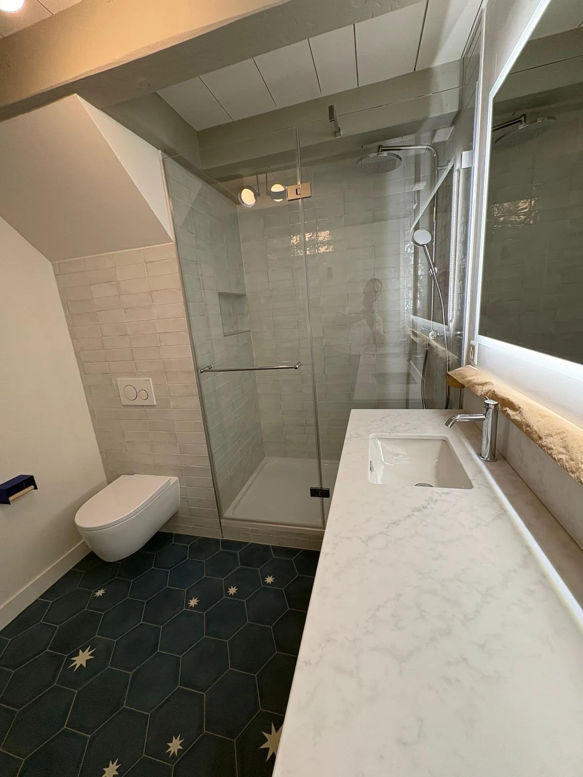 Douche vitrée et meuble vasque dans une salle de bain à Chéserex