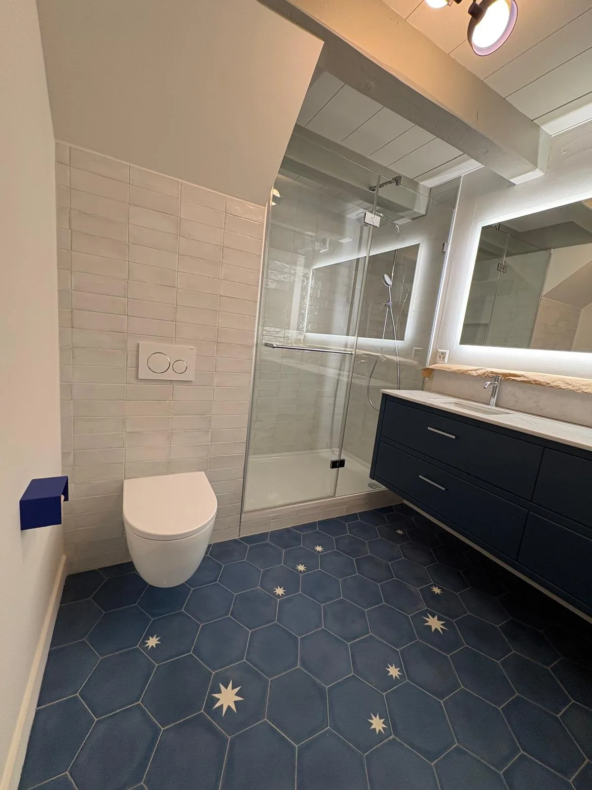 Douche fermée et WC suspendu dans une salle de bain à Chéserex