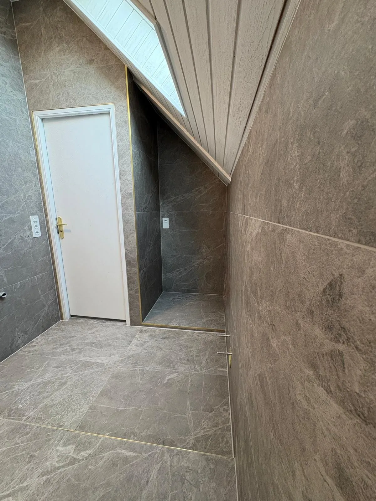 Niche sous pente carrelée dans une salle de bain à Crans