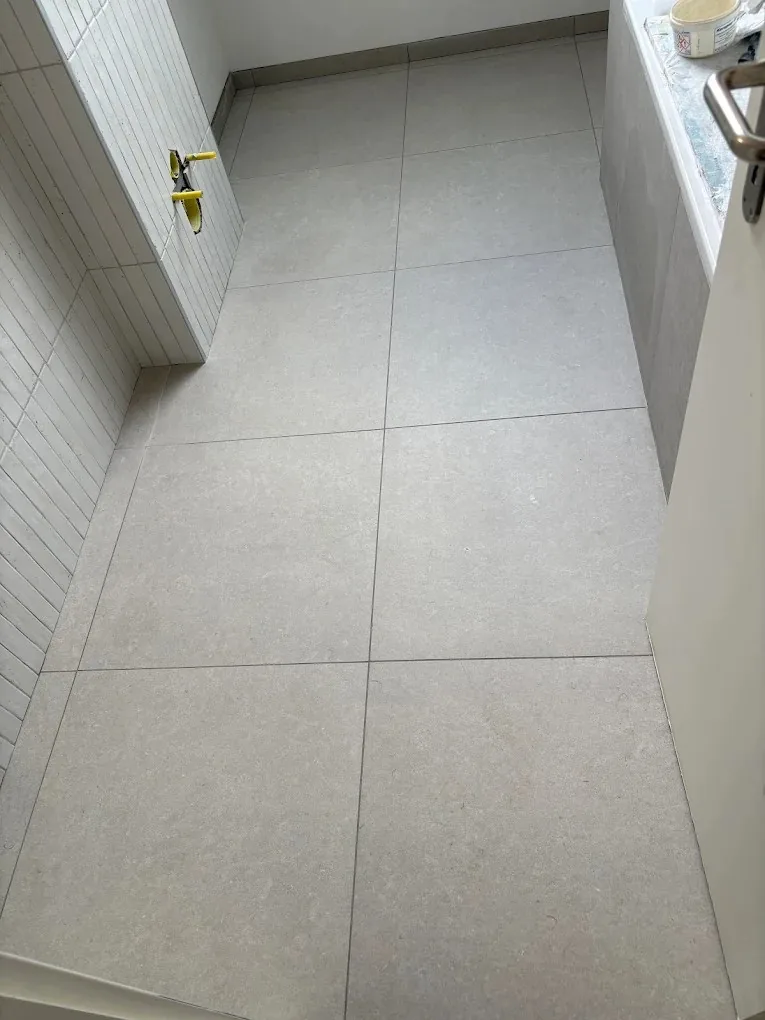 Carrelage de sol grand format posé dans une salle de bain à Trélex