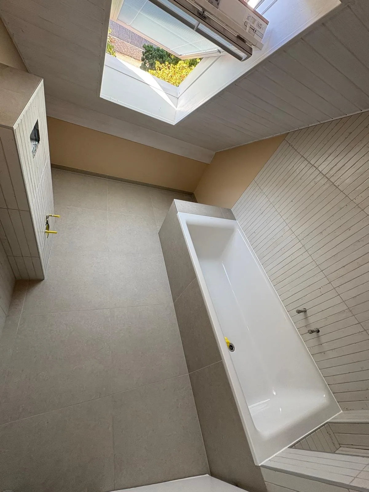 Baignoire sous une fenêtre de toit dans une salle de bain à Trélex