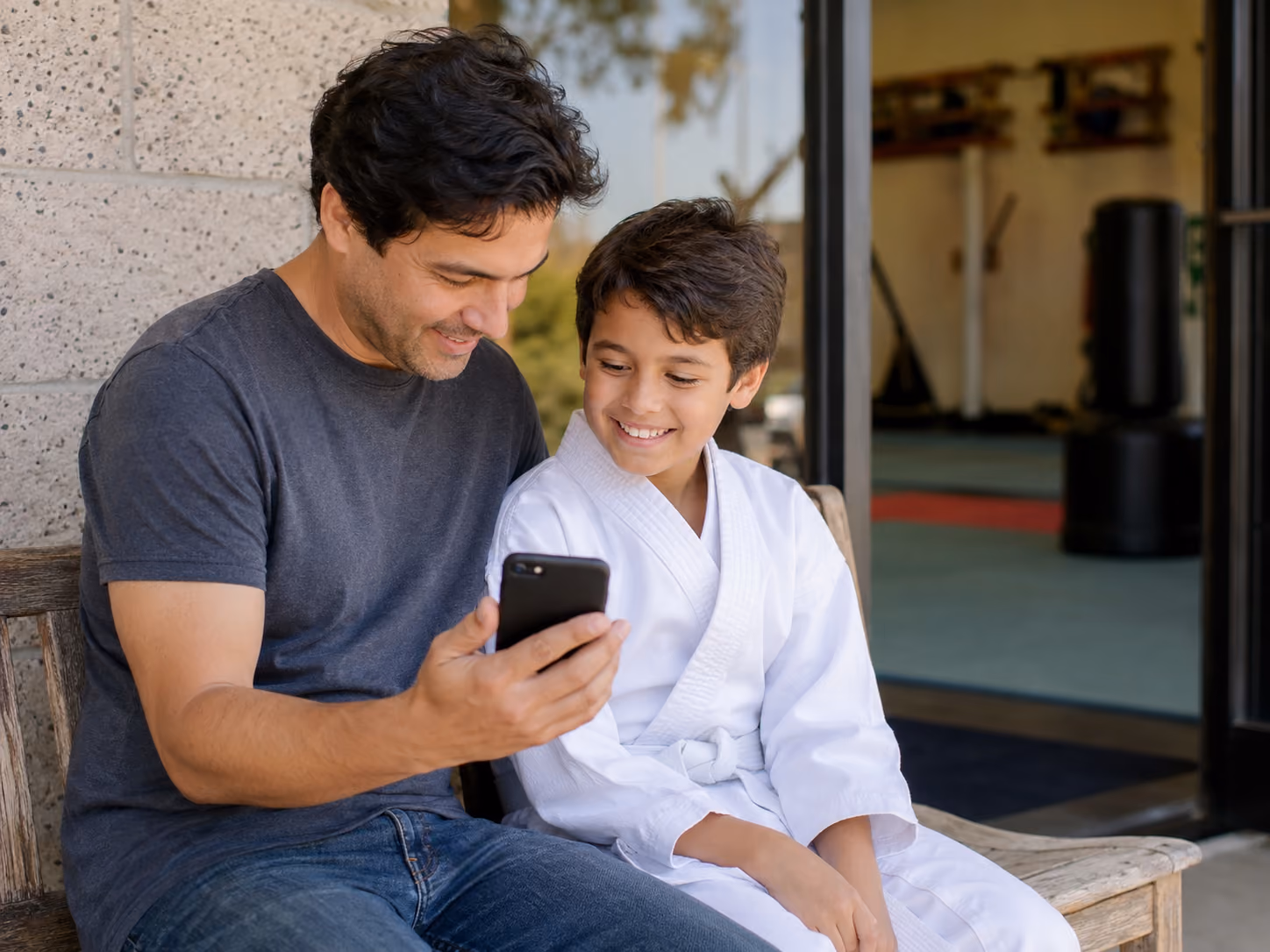 Parent and student using the MyStudio member app outside a martial arts school