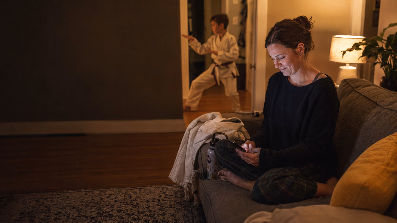 Parent looking up a martial arts school on a phone before enrolling