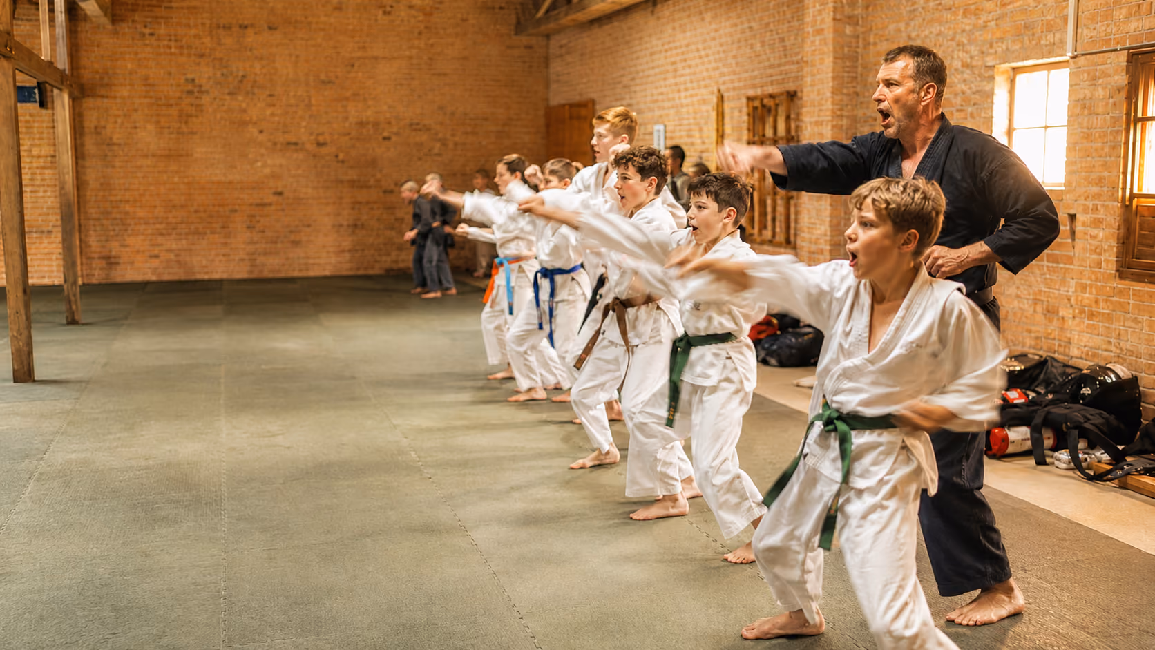 Martial arts instructor working with a young student during class