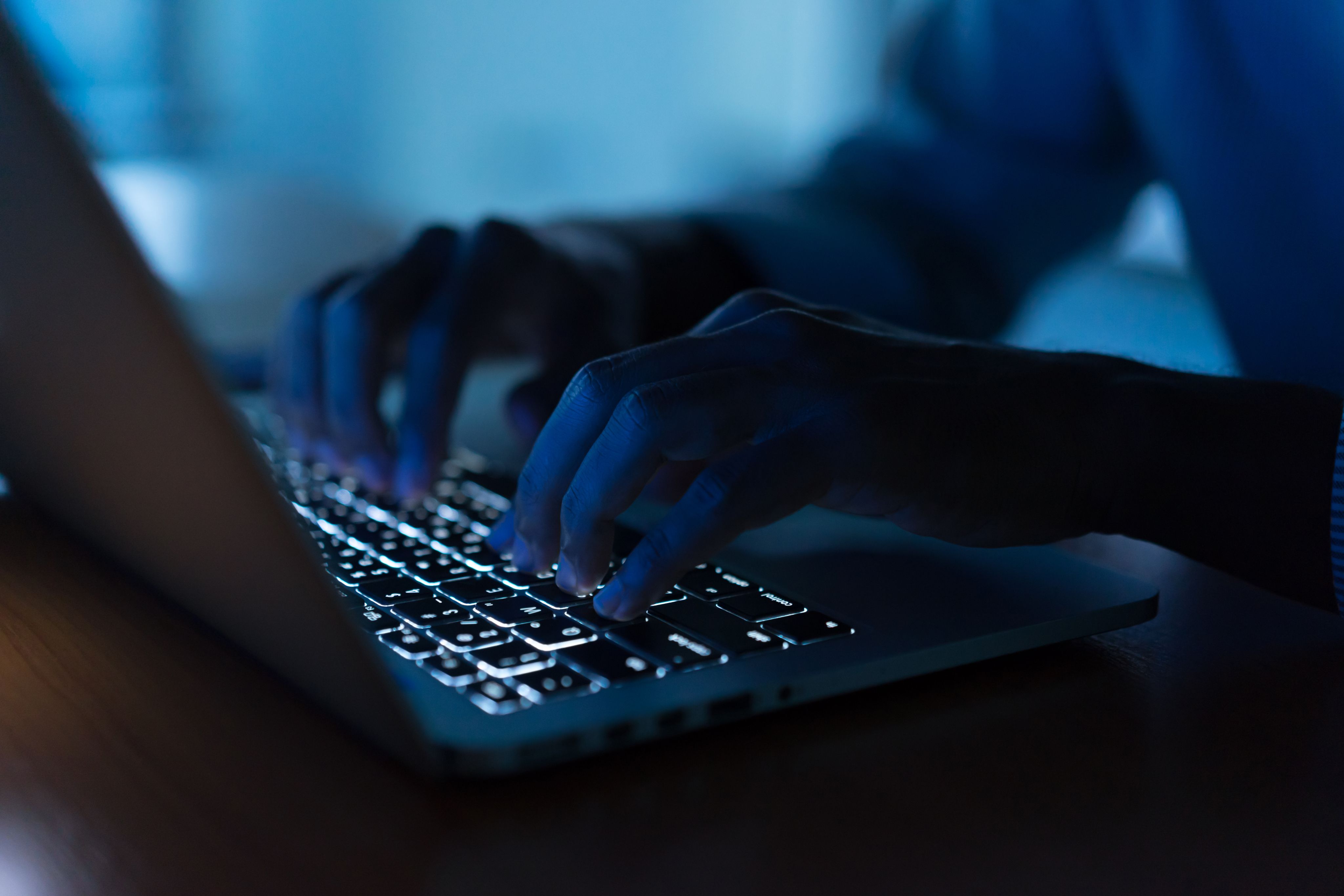one hand on a laptop