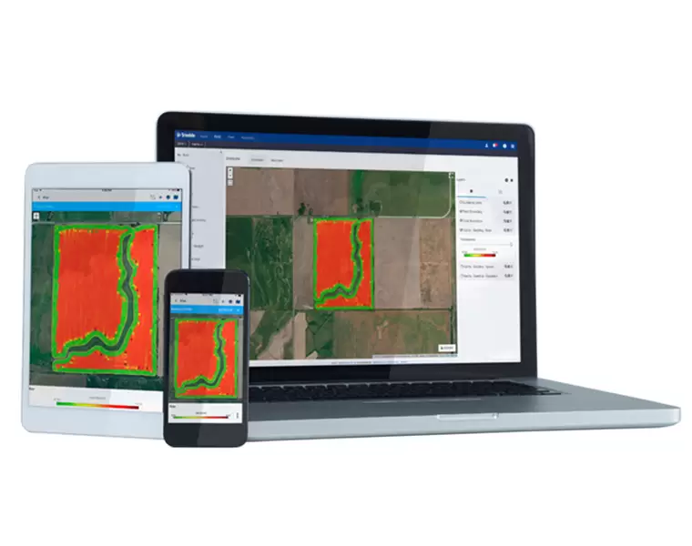 Ecran de laptop, tabletă și telefon mobil afișând o hartă agricolă cu zone colorate în roșu și verde, evidențiind perspective de teren agricol în software de monitorizare.