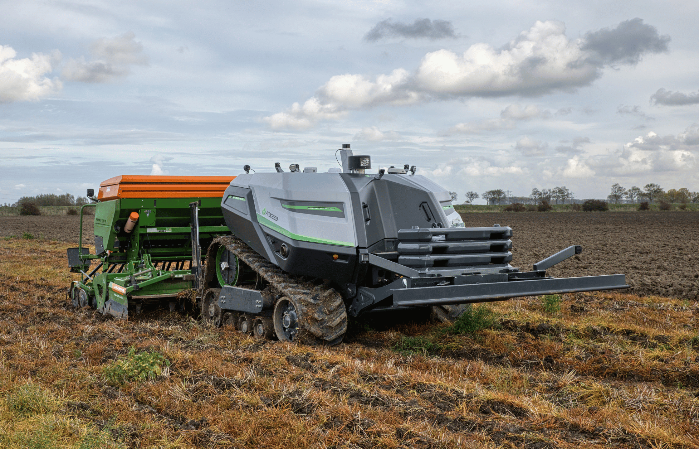 Robot agricol autonom AgXeed AgBot T2 seria 7 lucrând cu un utilaj atașat pe câmp.