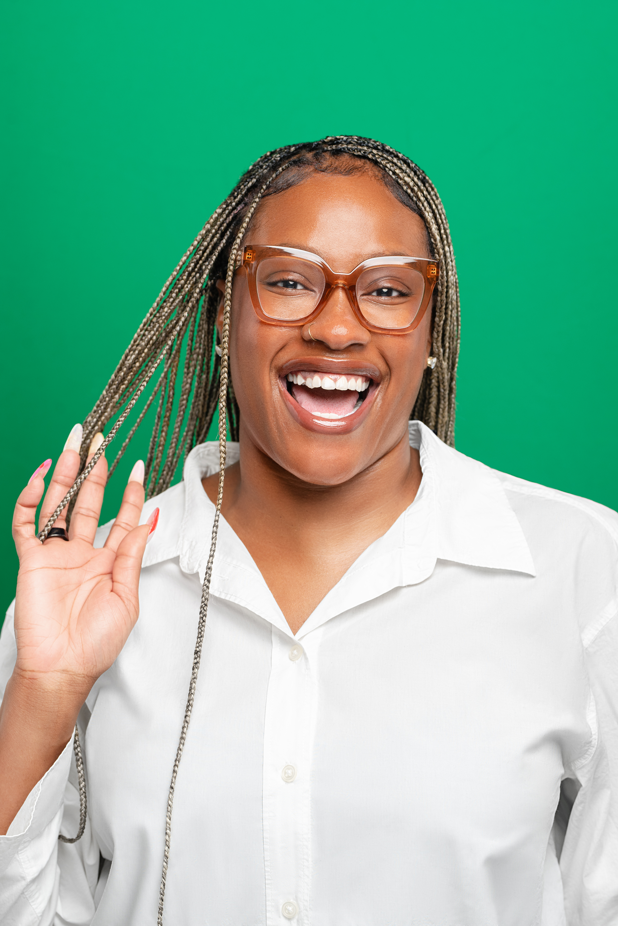 Professional portrait of a smiling woman in a white blouse against a green background