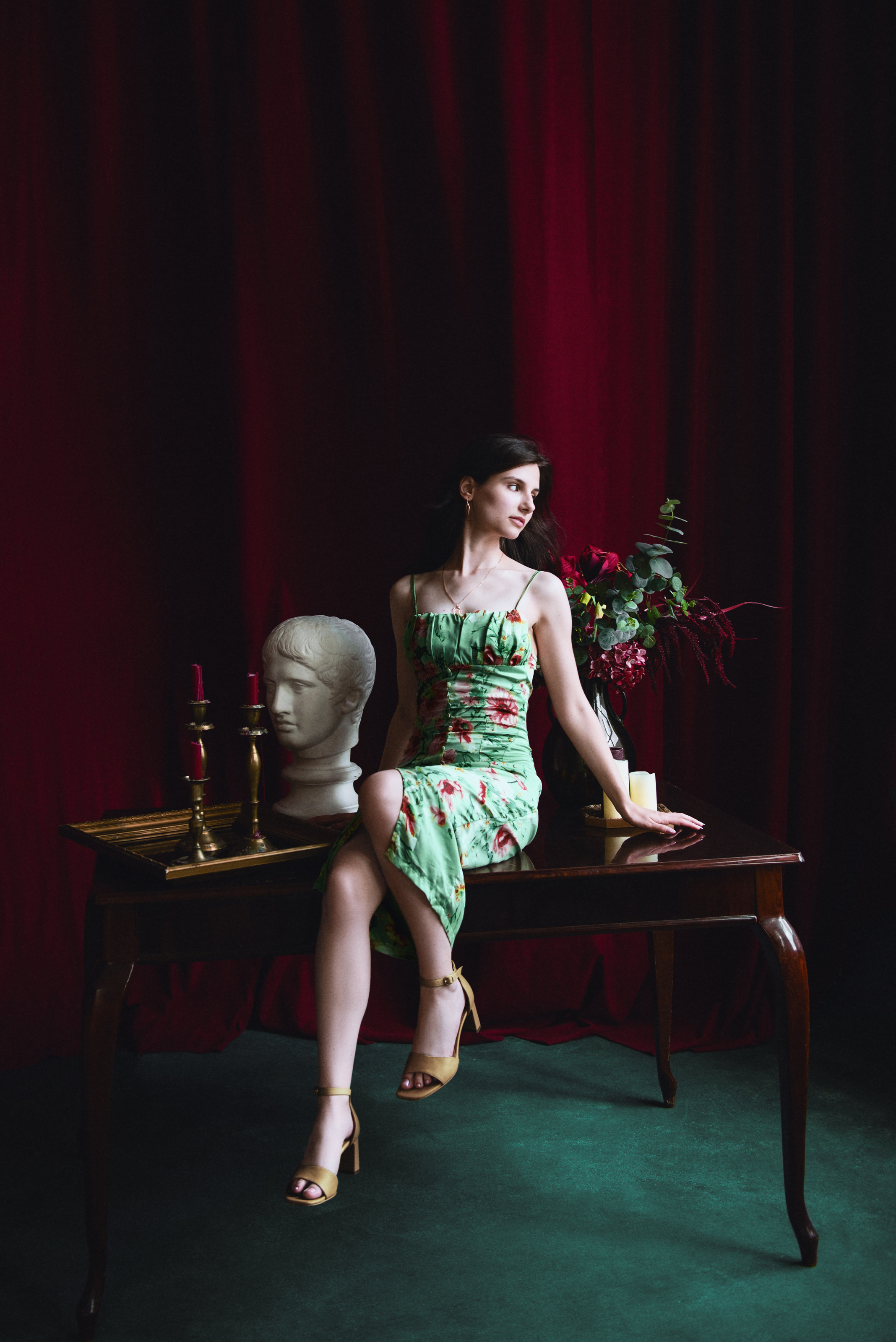 Retouched full-length portrait with refined skin, richer red curtains and balanced color throughout the studio scene.