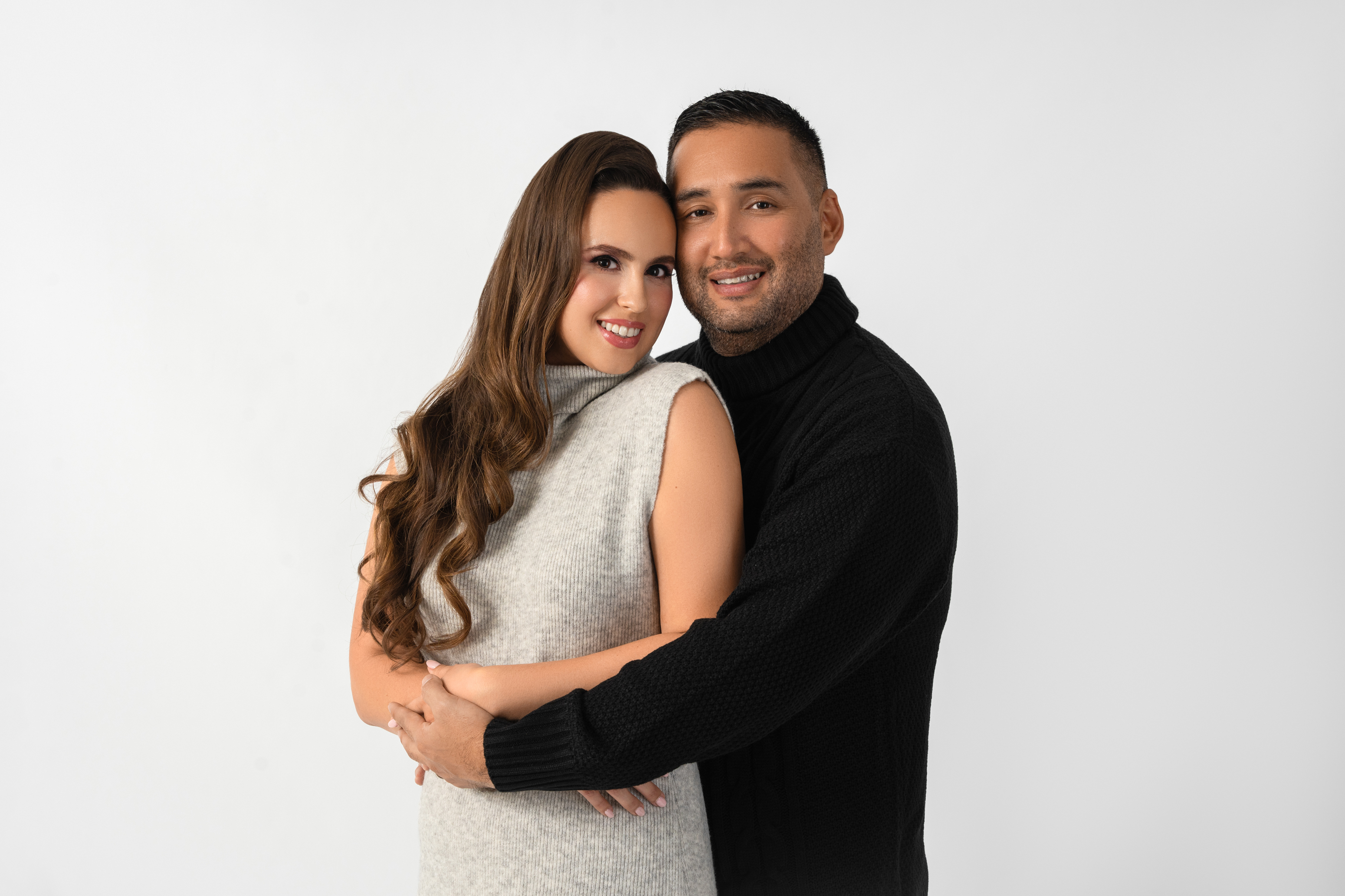 Studio portrait of a couple embracing against a clean white background