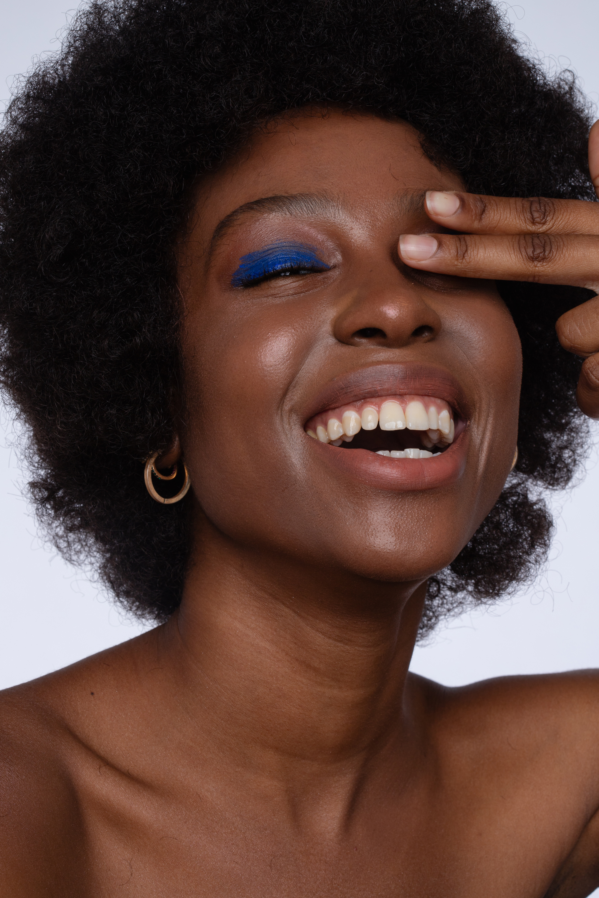 Final beauty close-up with natural skin texture, warm balanced skin tones and vivid blue eye makeup