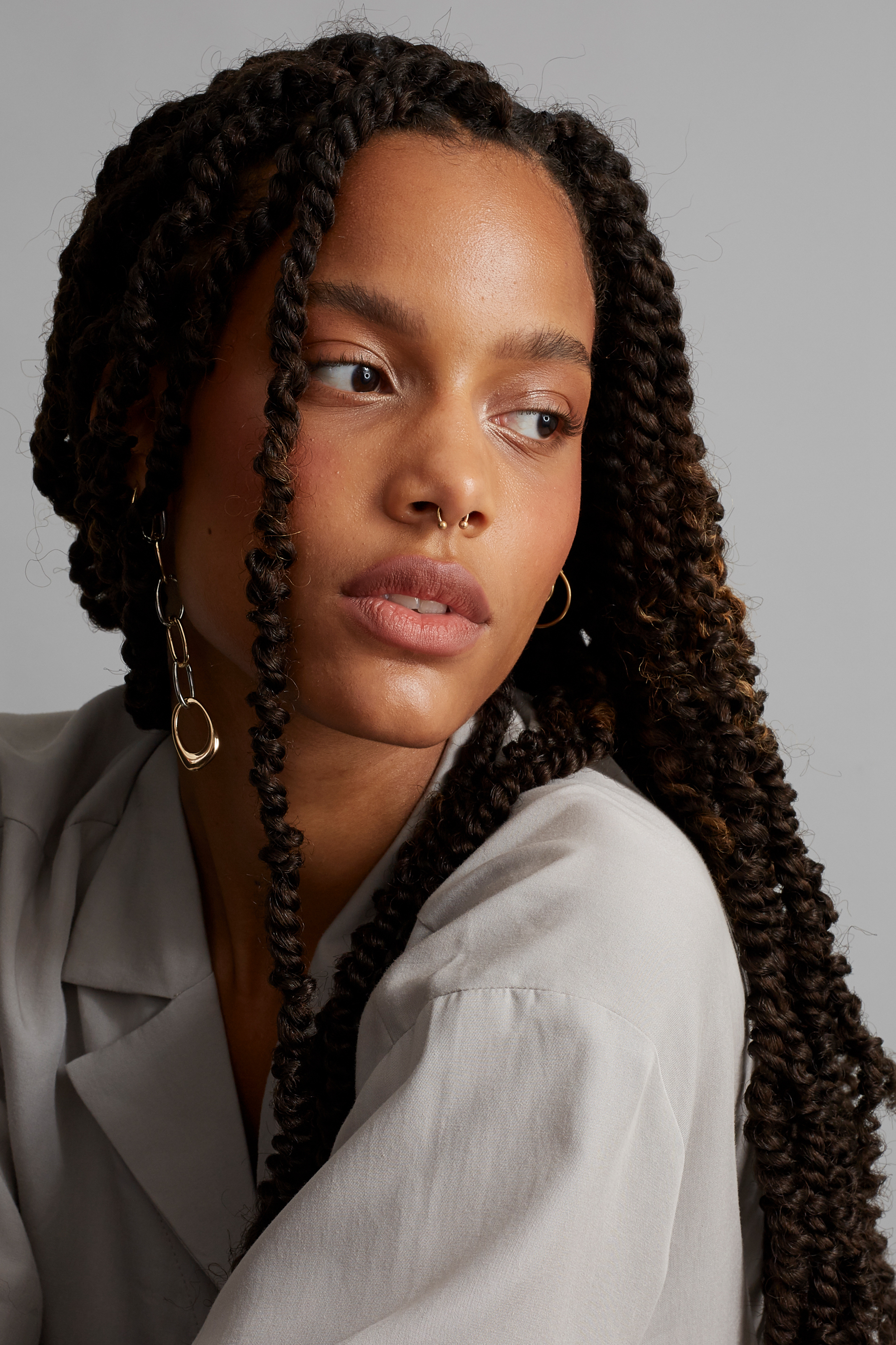 Beauty portrait before retouching, with long braids and soft neutral studio lighting