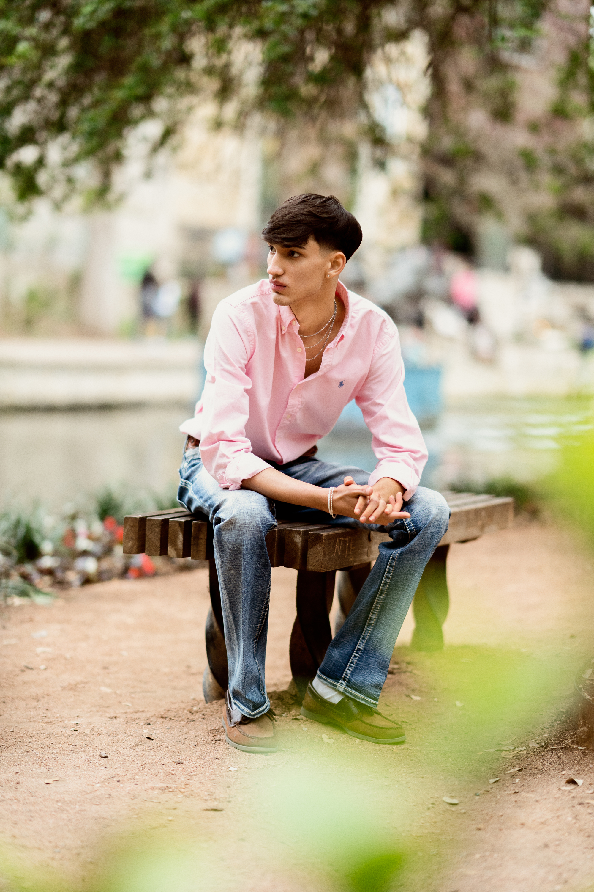 senior portrait of a teenage boy sitting on a bench outdoors