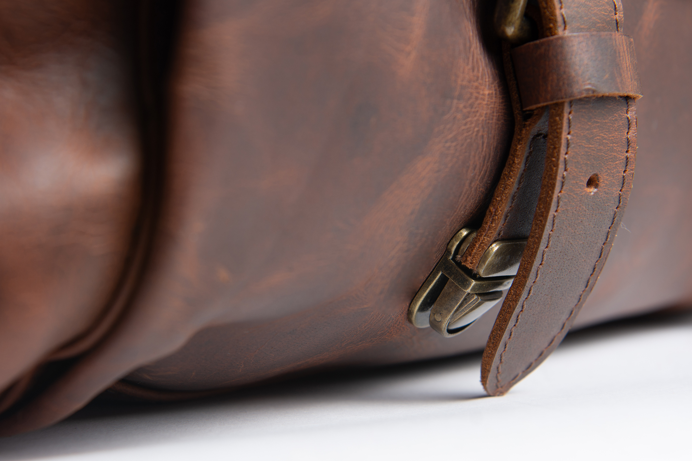 Close-up of a leather strap, buckle and textured surface before retouching