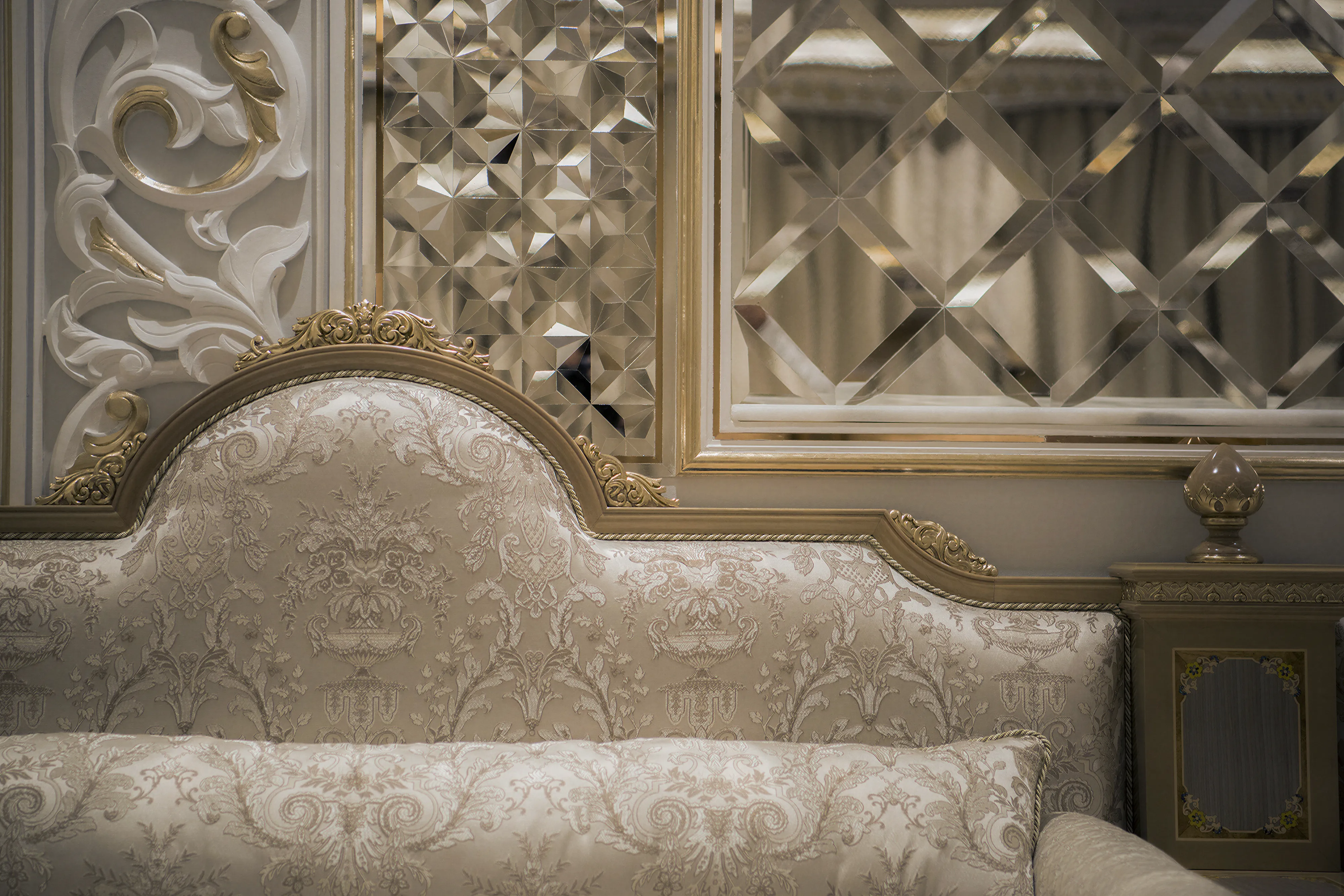 Close up of a luxury home interior, with custom furniture and glasswork. Platinum finishes and custom carving details. Mirrored.