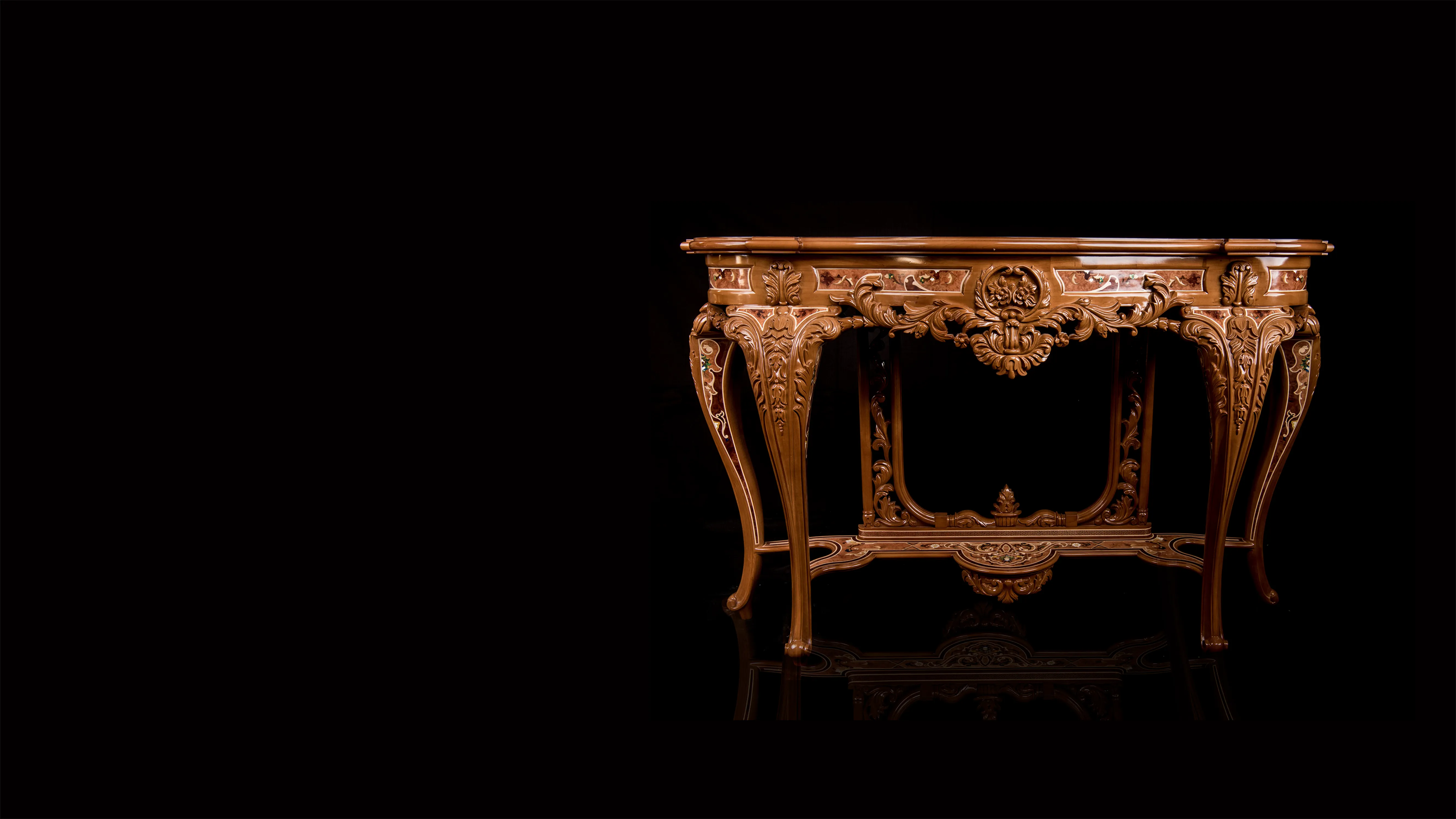 Front view of a traditional luxury wood inlay, custom console made of mahogany and a wood-pearl top. Infused with mother of pearl. On a black background and reflective floor. Showing carved base.  