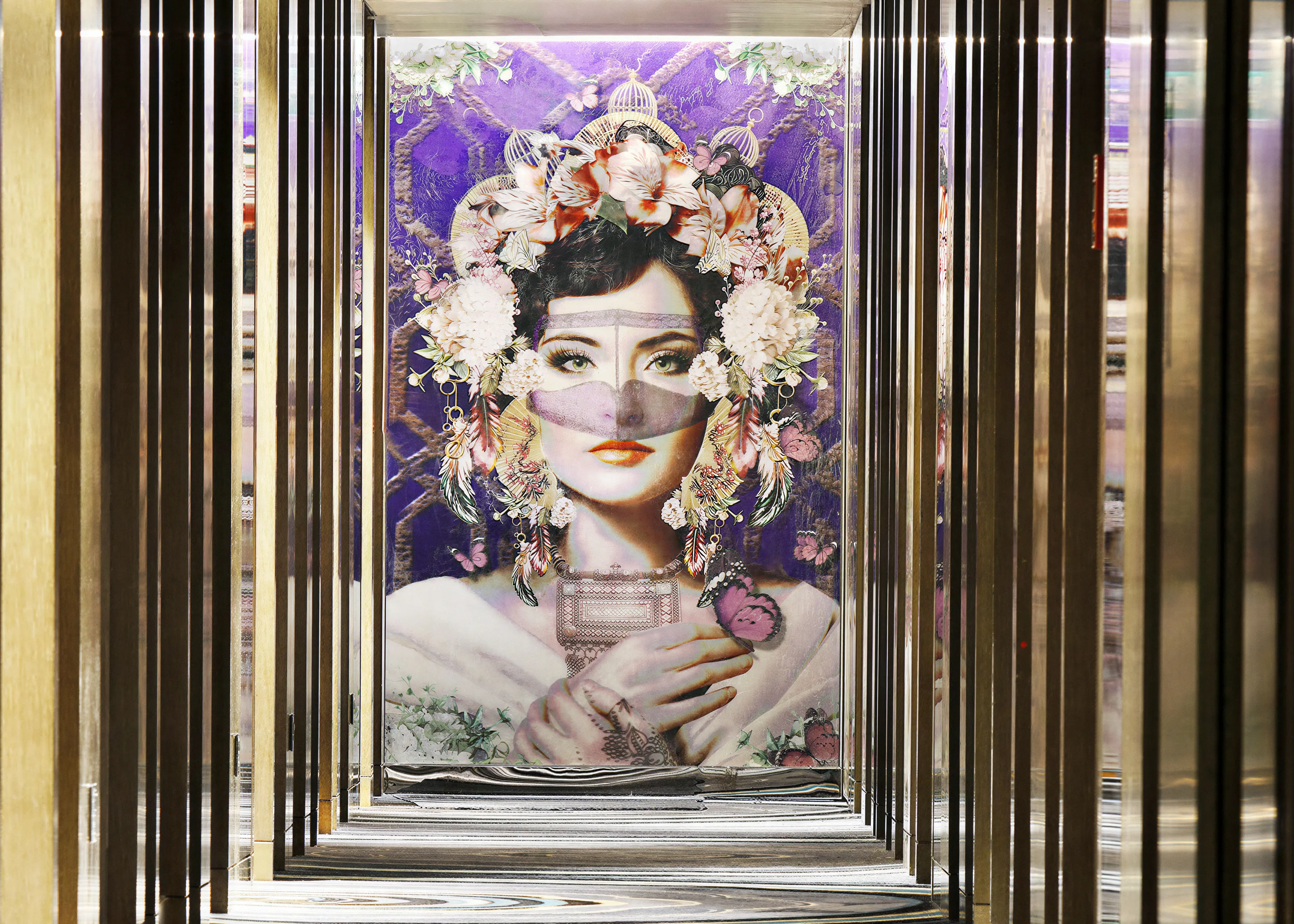 Lenticular interactive artwork of a woman with a beautiful flower headdress and ornamental clothing.  In a hotel corridor.