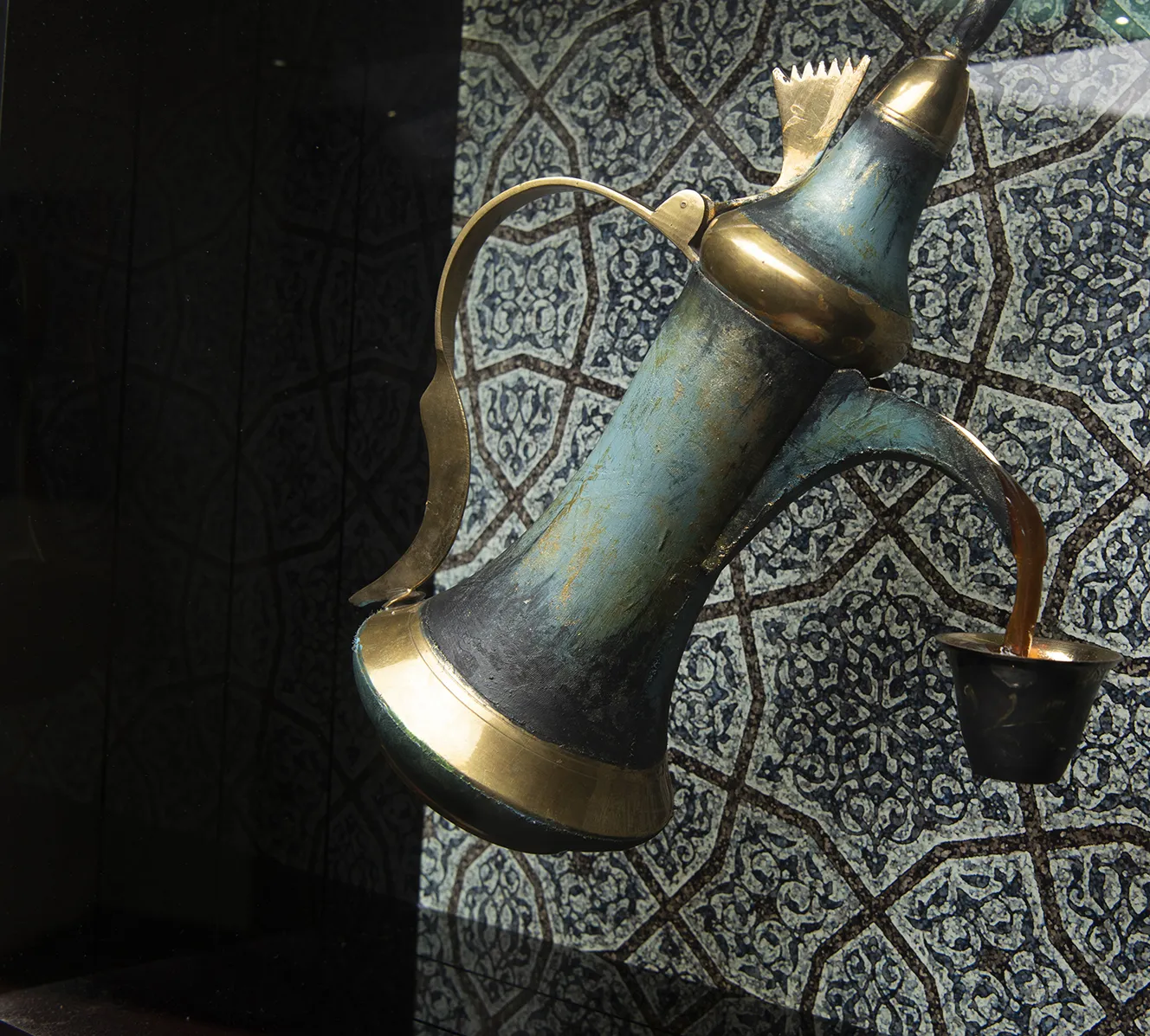 High-tech sculpture of a coffee pot, frozen in time mid-pour. Painted with transitional paint, suspended in the air with our levitation technology. On a backlit custom graphic.