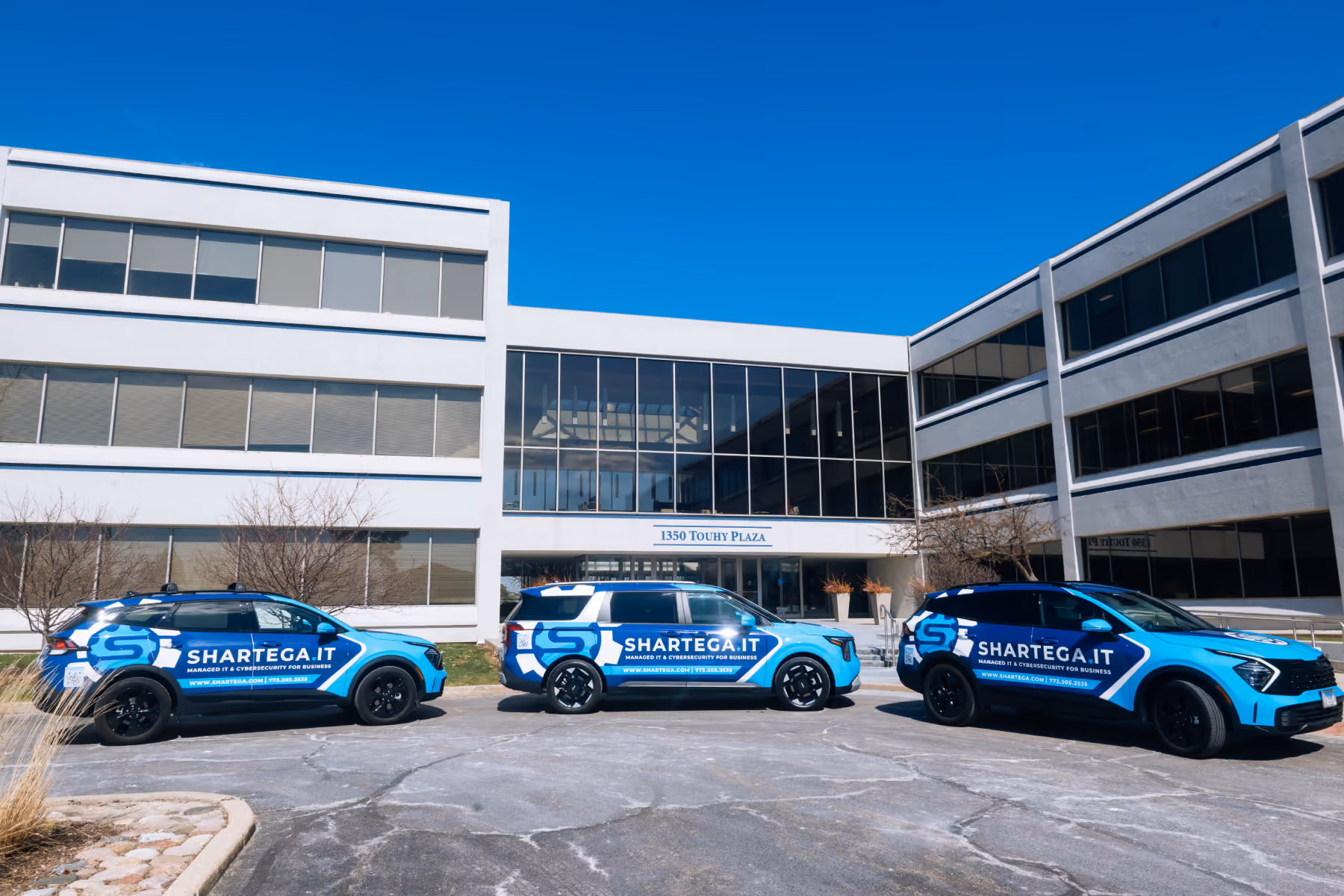 Shartega IT headquarters with branded service vehicles parked outside