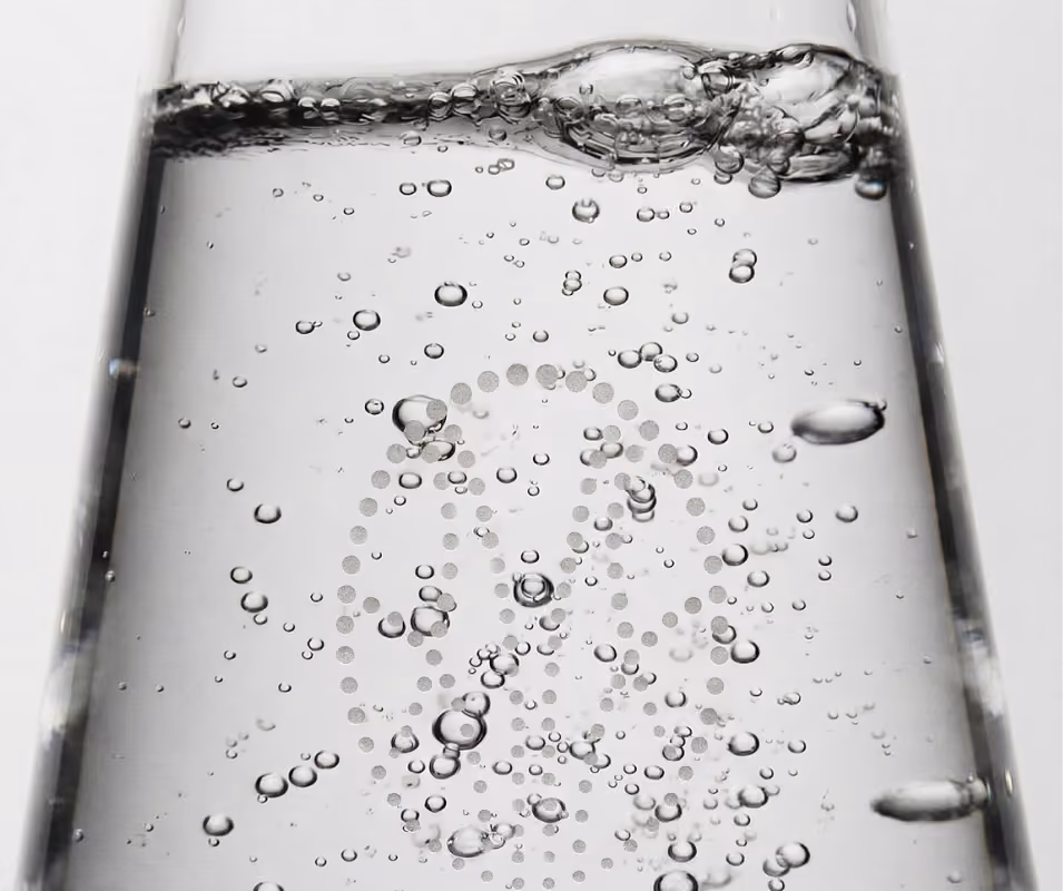Bouteille en verre qui se remplit d’eau pétillante