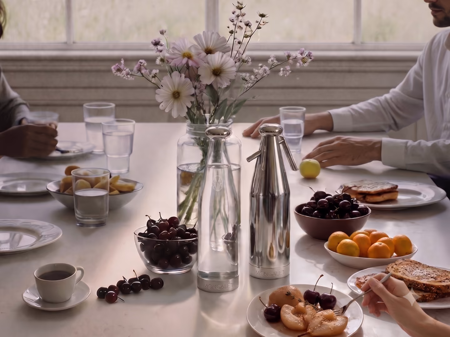 Table de petit-déjeuner avec fleurs, fruits et bouteille Mongalet
