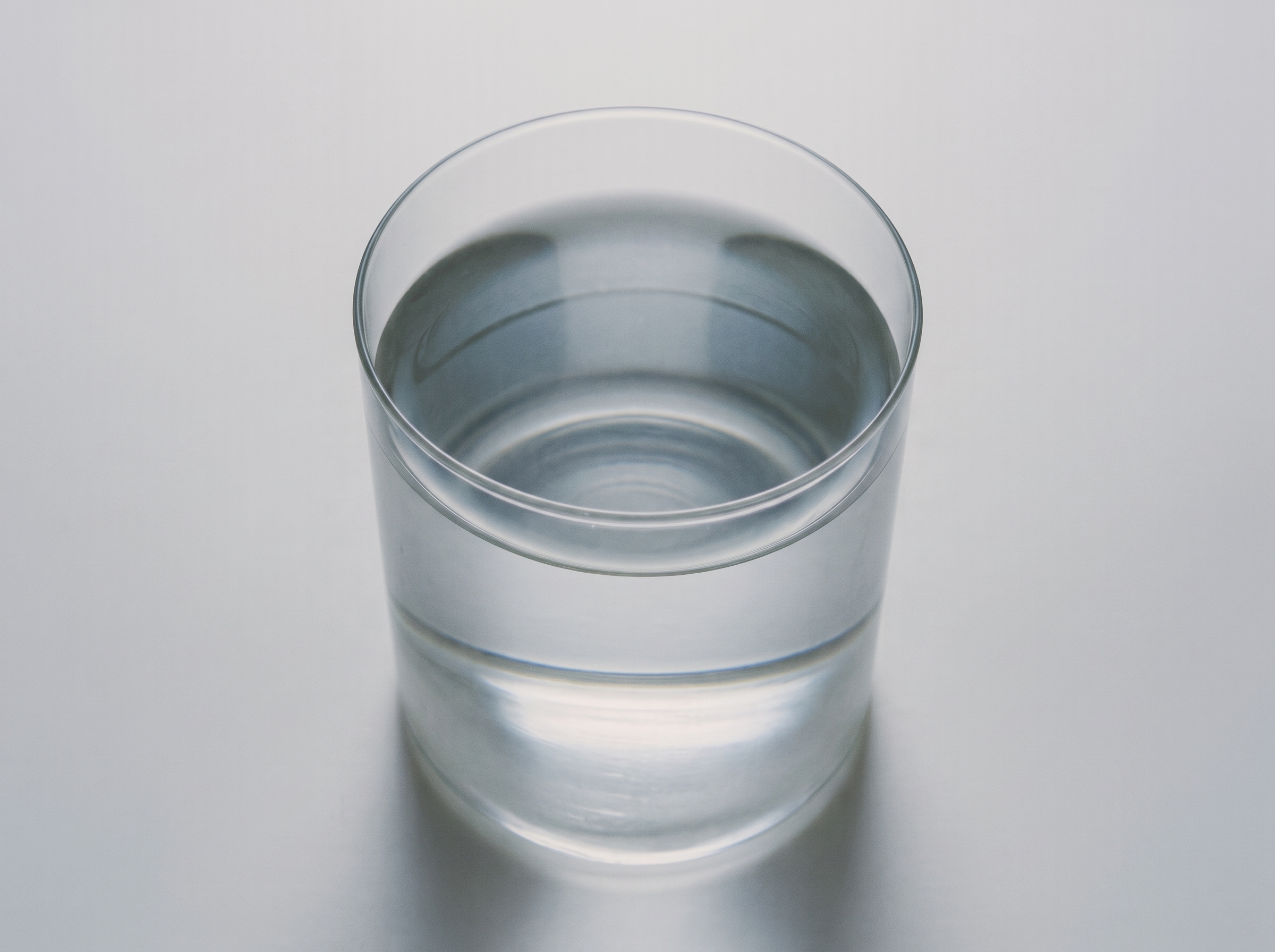 Verre d'eau Mongalet posé sur fond gris