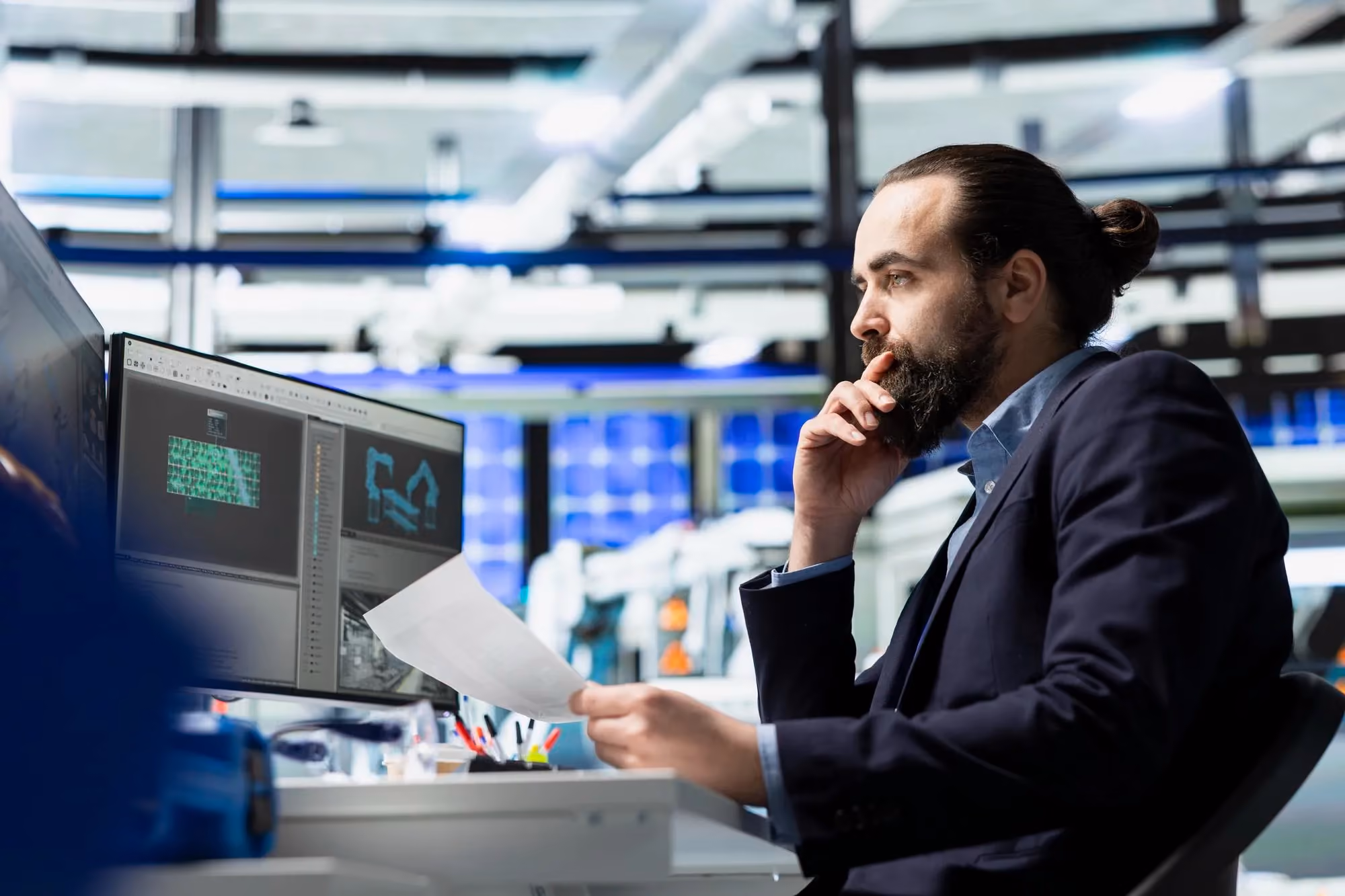 Engineer reviewing test data on a workstation monitor in an industrial lab