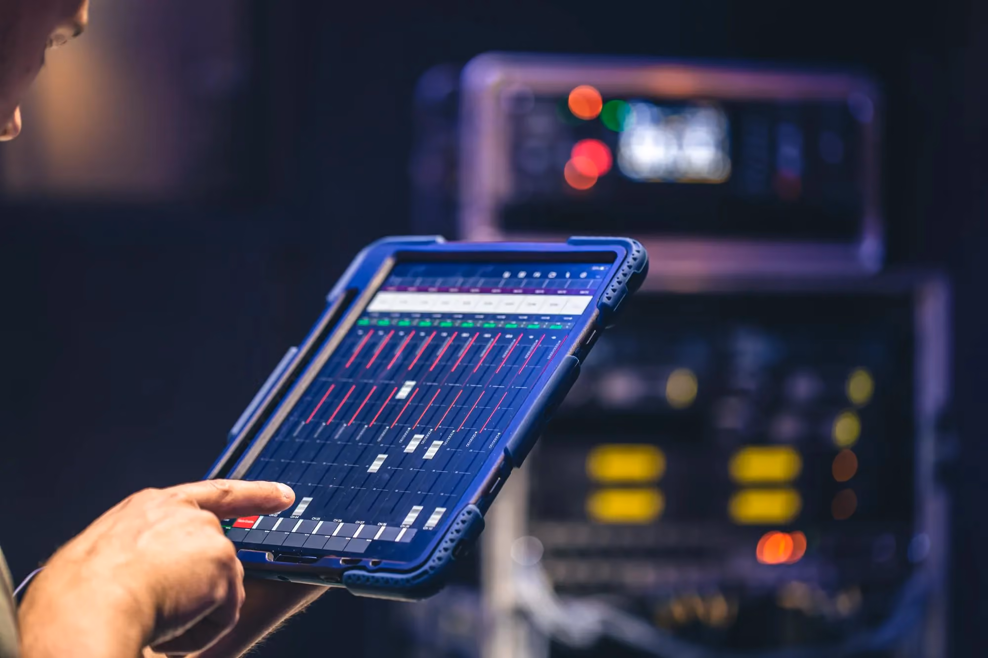 Engineer operating a control interface on a rugged tablet beside instrumentation racks