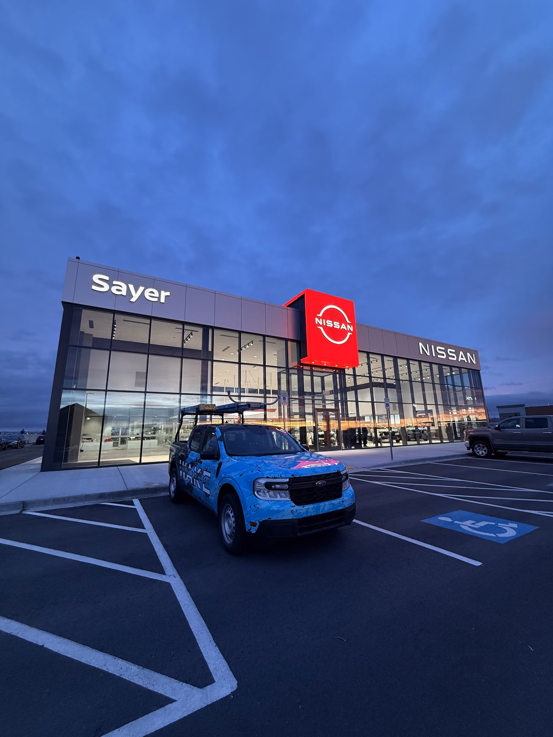 Wake Window Cleaning technician cleaning exterior glass at a Nissan dealership in Idaho Falls