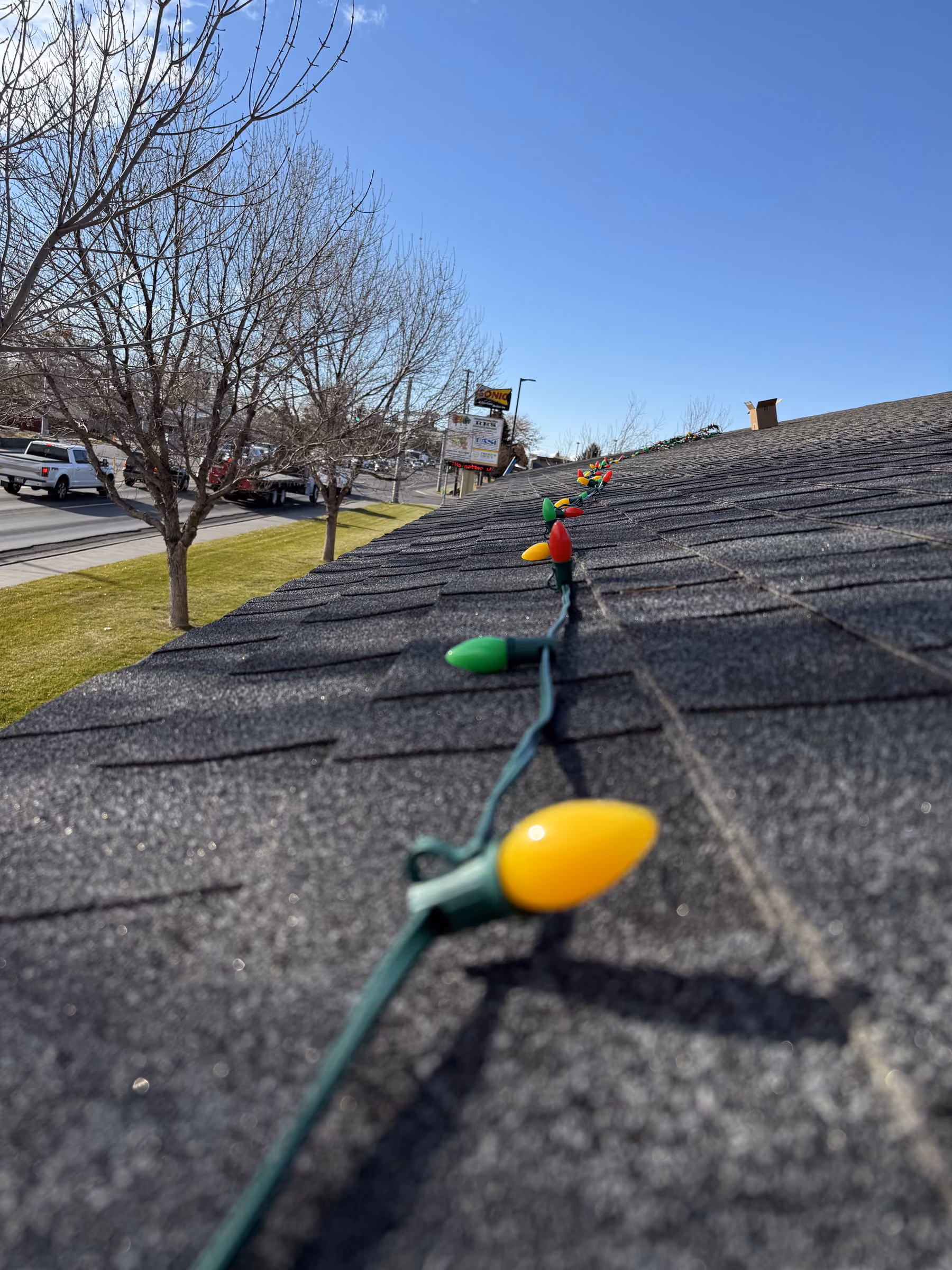 Wake Window Cleaning installing C9 holiday lights along a roof ridge in Southeast Idaho