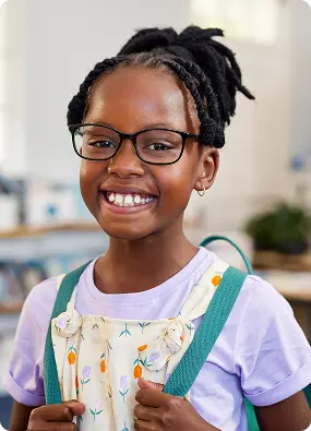 Smiling student with glasses and backpack ready for school