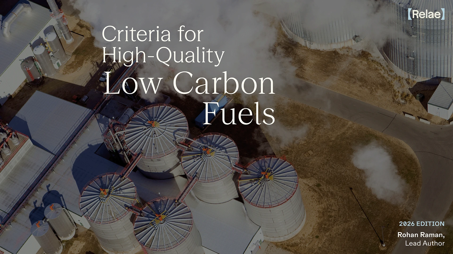Aerial view of industrial storage tanks connected by pipes with steam rising, overlaid with the text: Criteria for High-Quality Low Carbon Fuels, 2026 Edition, Rohan Raman, Lead Author, and the logo Relæ.