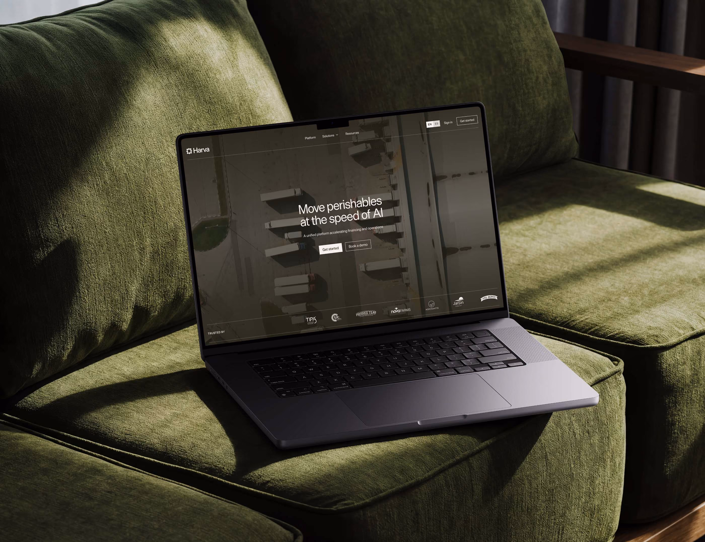 Laptop on a green sofa showing the Harva website